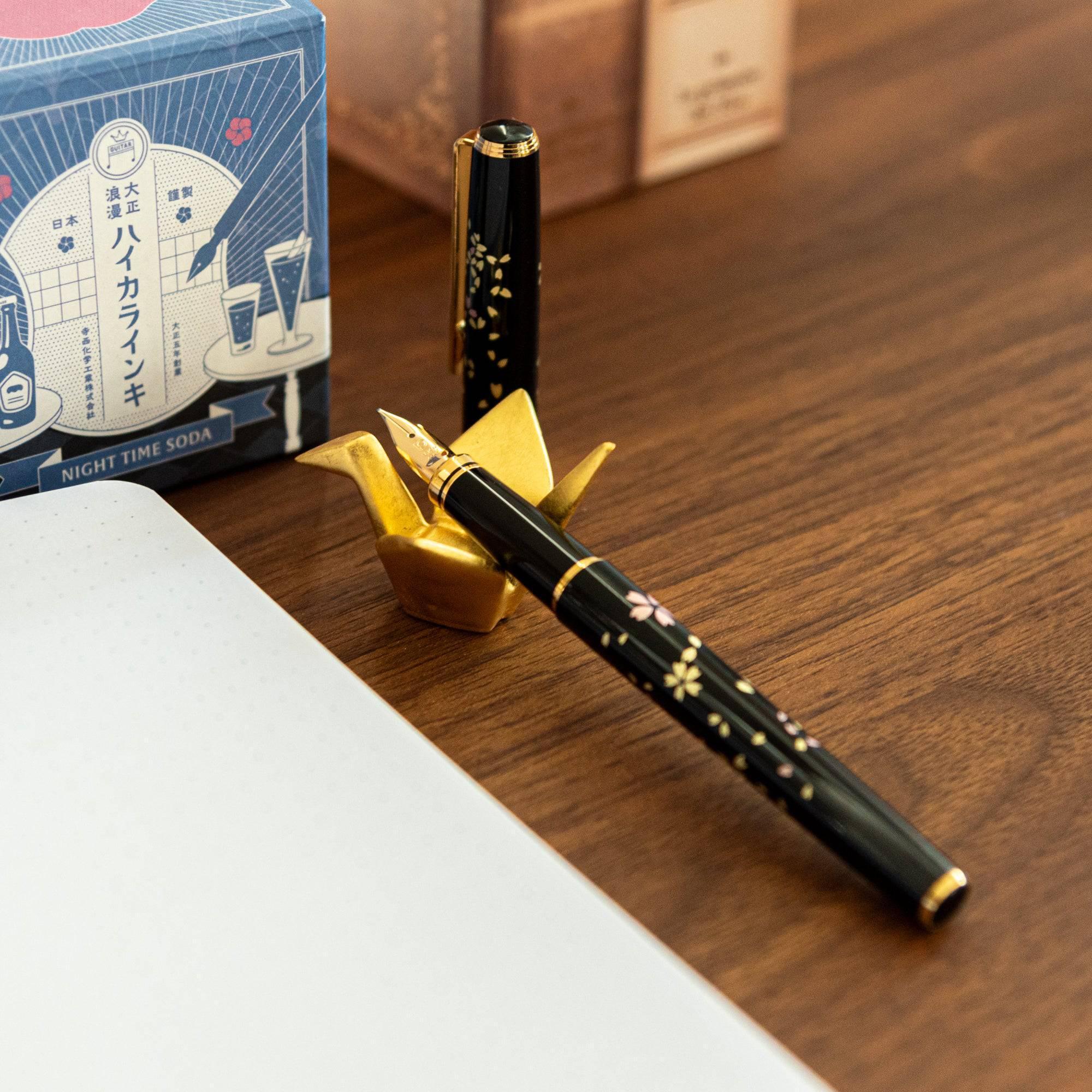 Japanese gold ceramic crane pen rest showing detailed feather carving and textured surface on white background