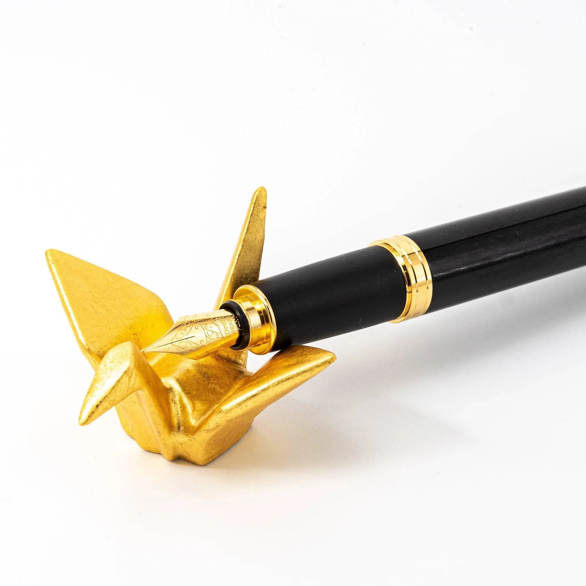 Japanese gold crane pen rest angled view showing carved pen rest groove and auspicious design detail