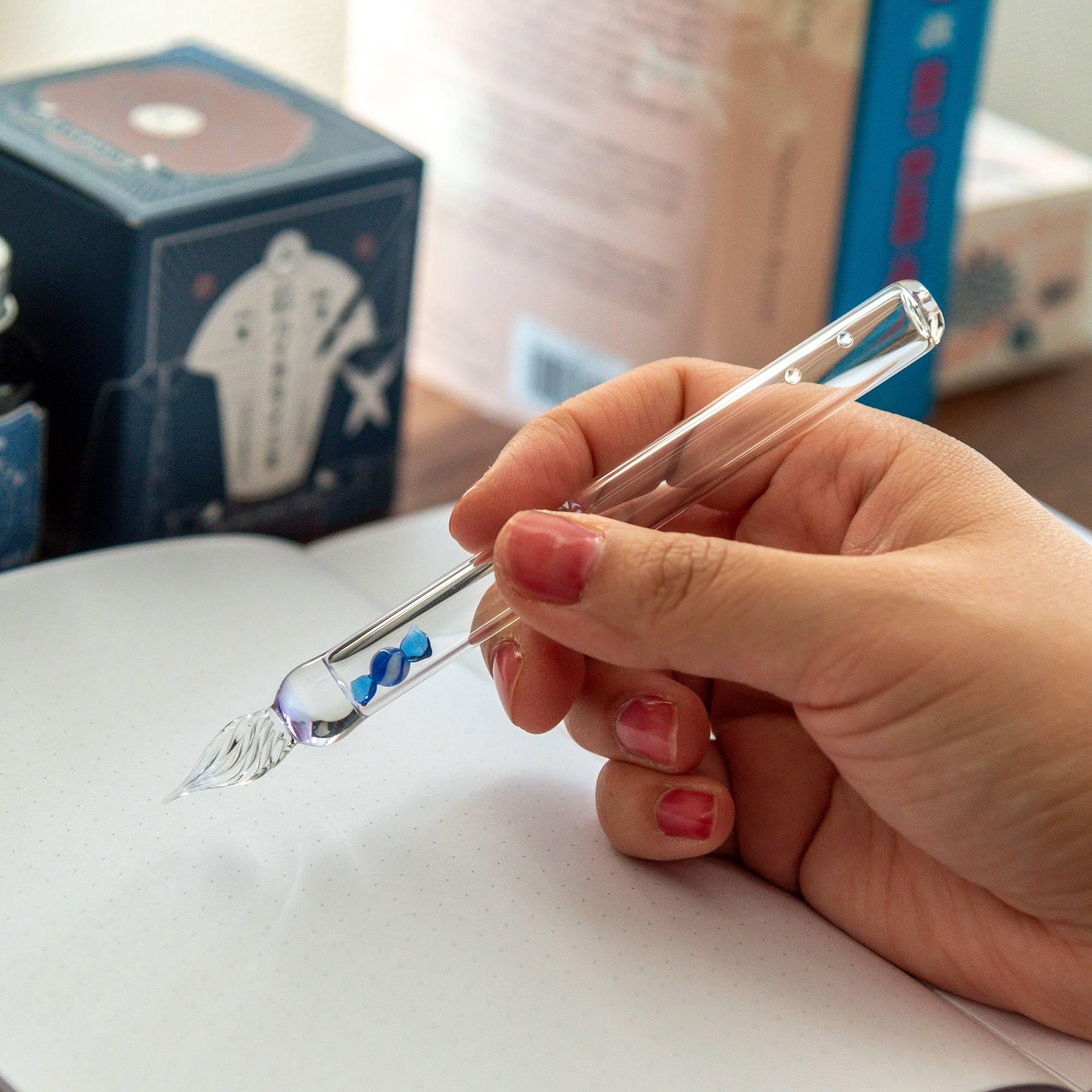 Blue candy glass dip pen featuring hand-twisted fine glass nib detail for calligraphy writing on white background