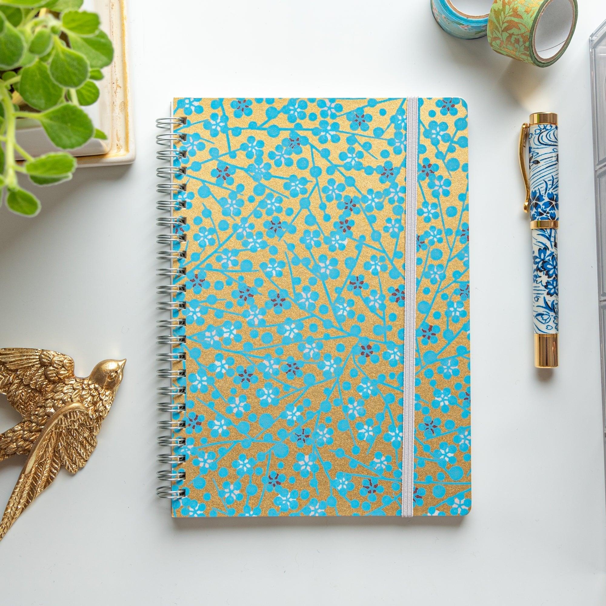 Japanese hand-dyed Yuzen washi spiral-bound notebook with blue flower design in protective packaging