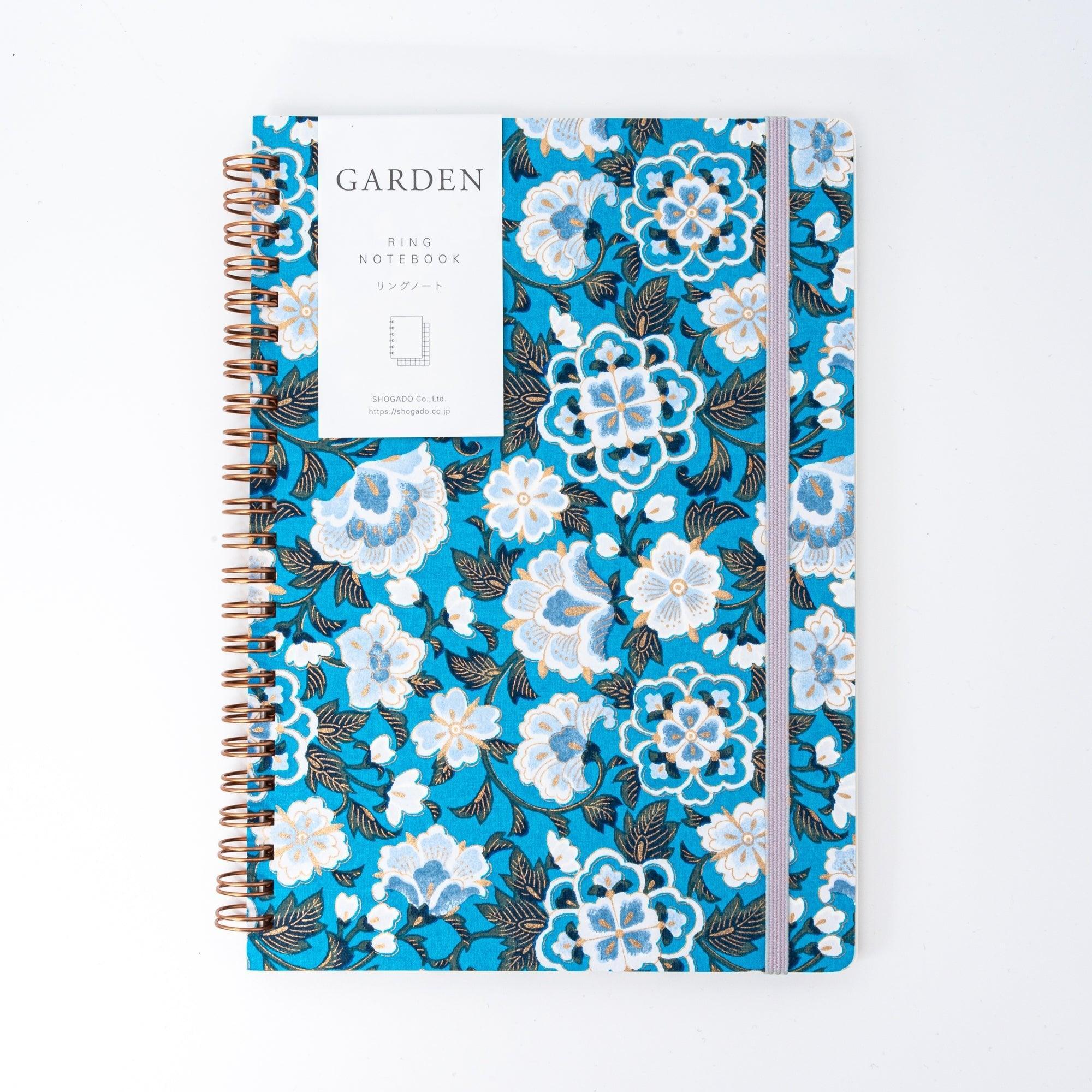 Japanese hand-dyed Yuzen washi spiral-bound notebook with blue garden design in protective packaging