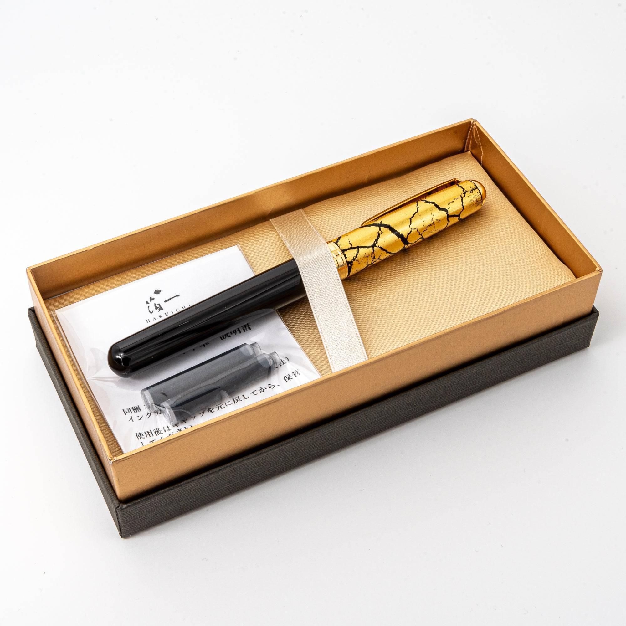 Capped black fountain pen with intricate gold crackle pattern, fine Japanese lacquer, product photograph