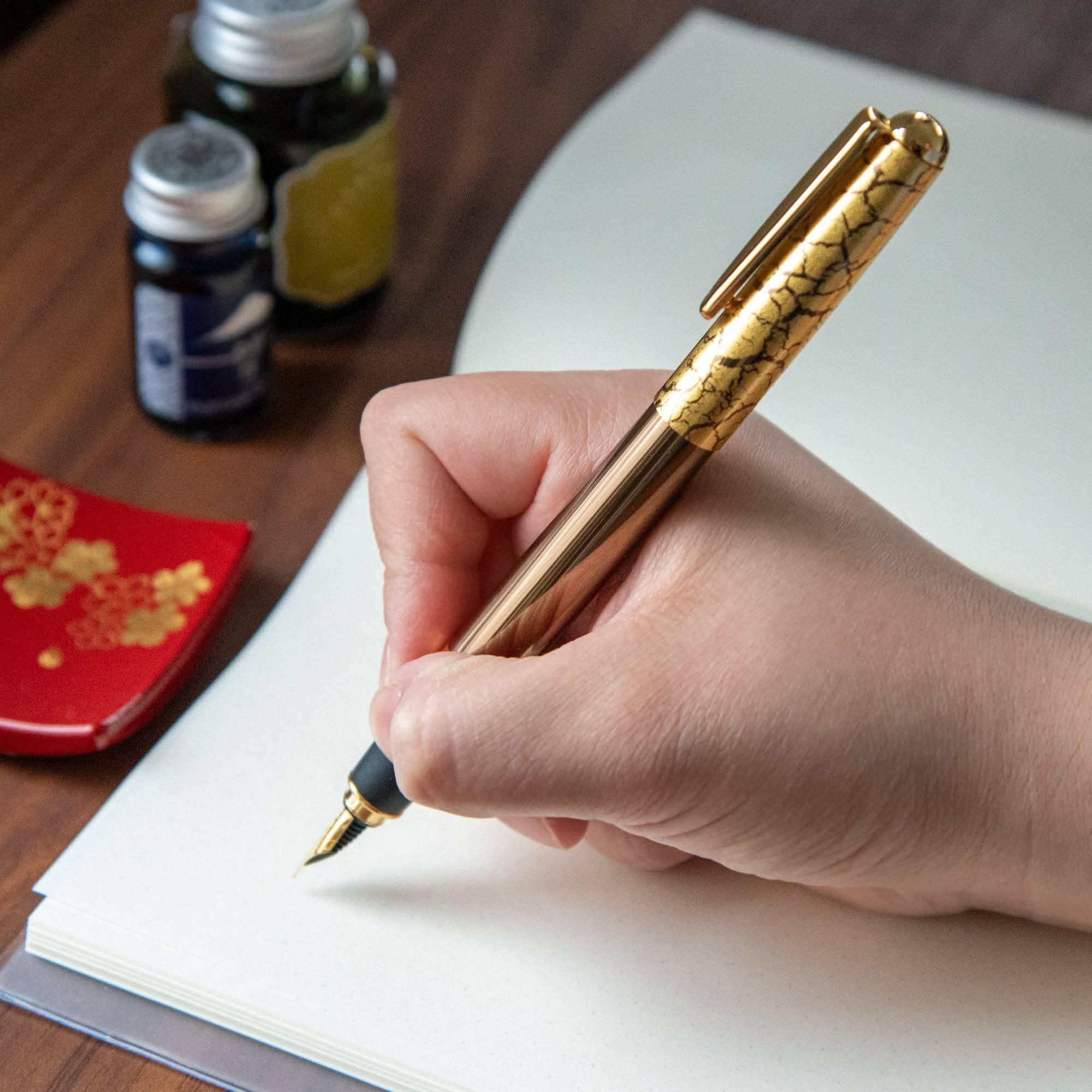 Crack Pattern Gold Leaf Brown fountain pen held in hand writing showing gold leaf crackle design detail