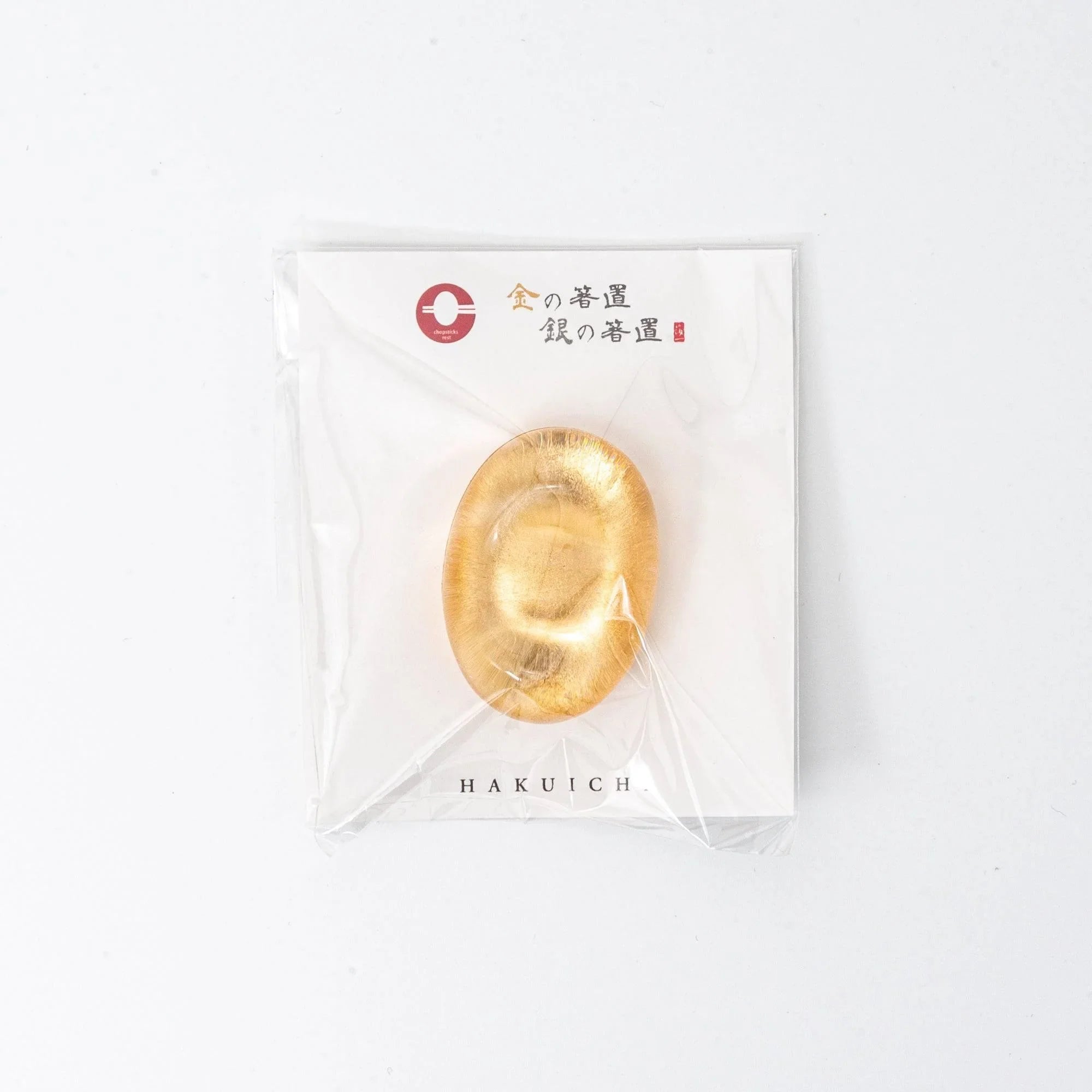 Japanese amber glass pen rest with delicate floating gold leaf accents visible in translucent organic bowl shape design