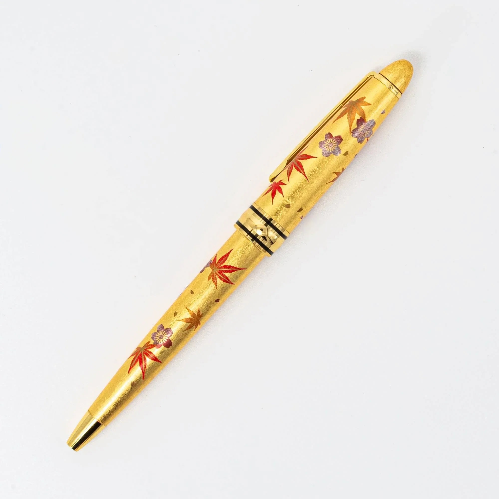 Angled view Gold Leaf Sakura and Momiji ballpoint pen with cherry blossom and maple leaf gold makie design