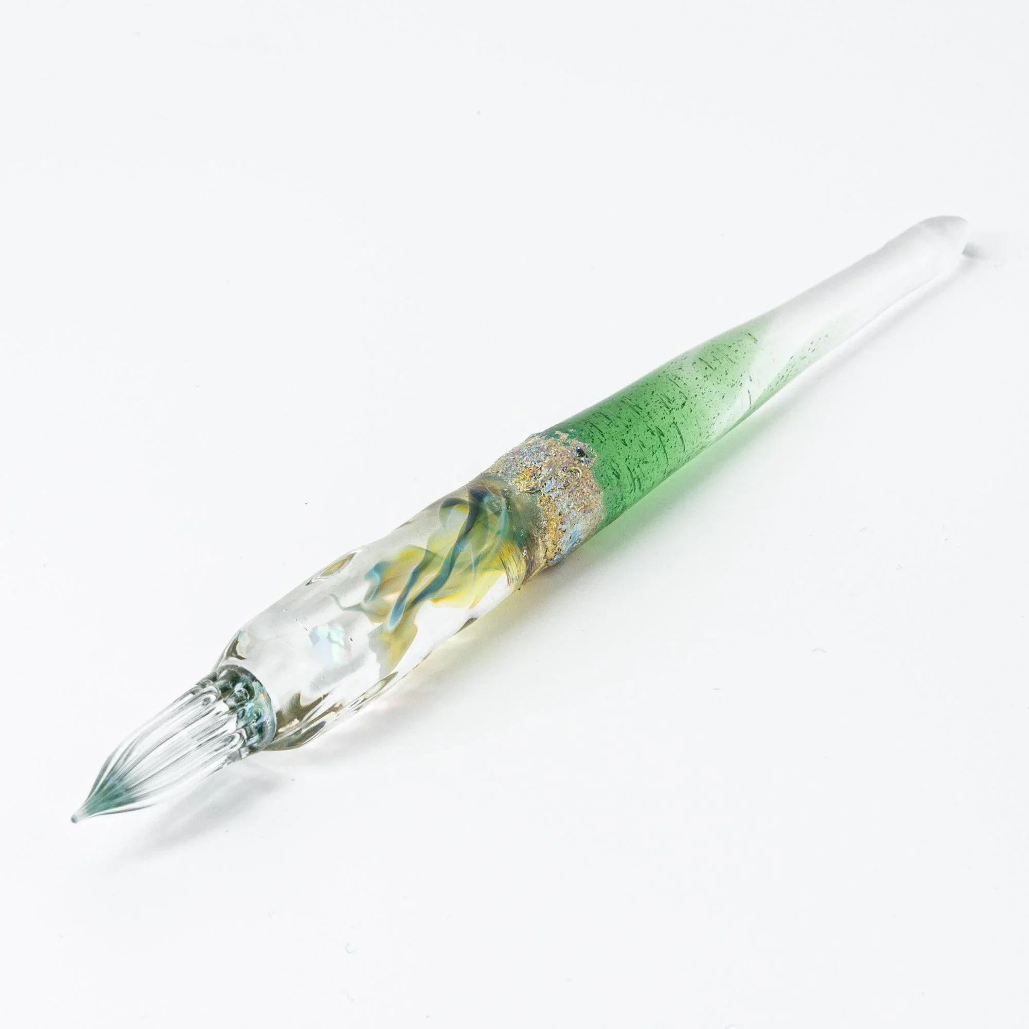 Tsukuyomi green glass dip pen displayed at diagonal angle showing gradient color and decorative metal nib detail