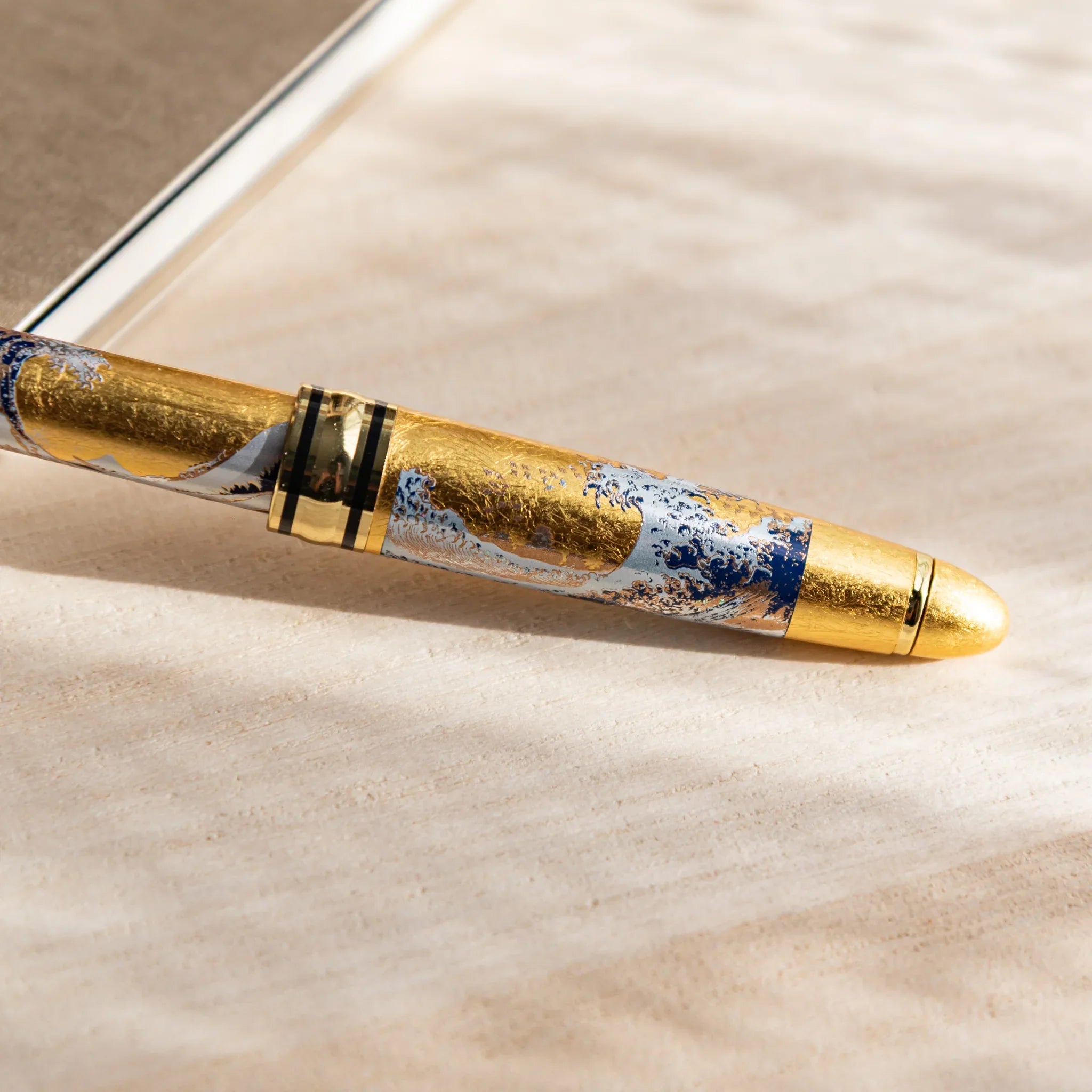 Great Wave gold leaf ballpoint pen at angle showing barrel decoration and pattern displayed clearly composition