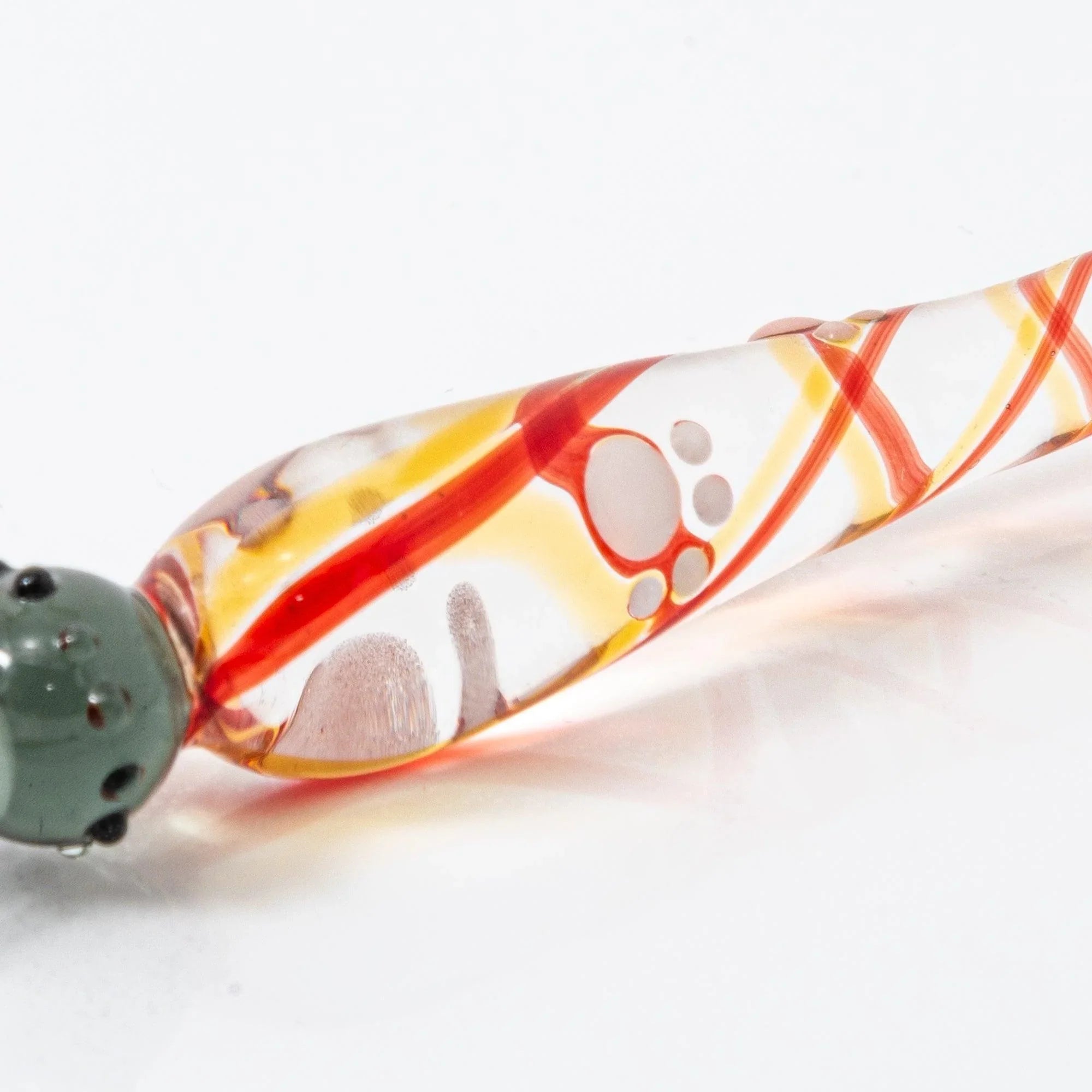 Black Nyanko cat paw pad close-up on glass dip pen barrel with colorful red-orange-yellow handle design