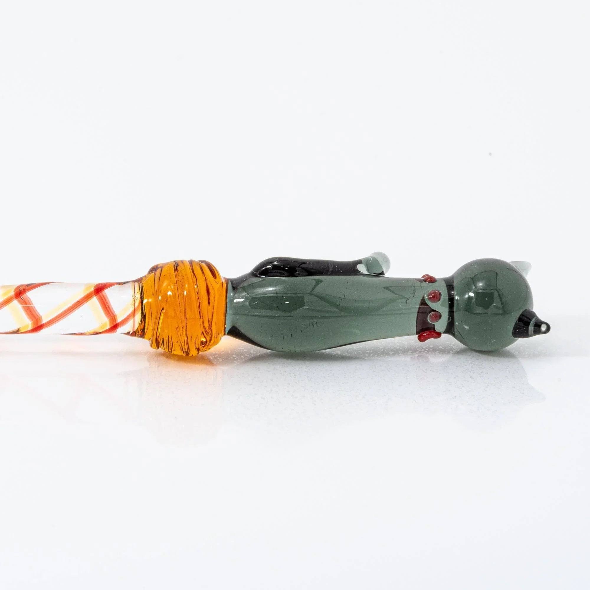 Black Nyanko glass dip pen in hand with dark green cat and red-orange-yellow decorative spiral handle bands