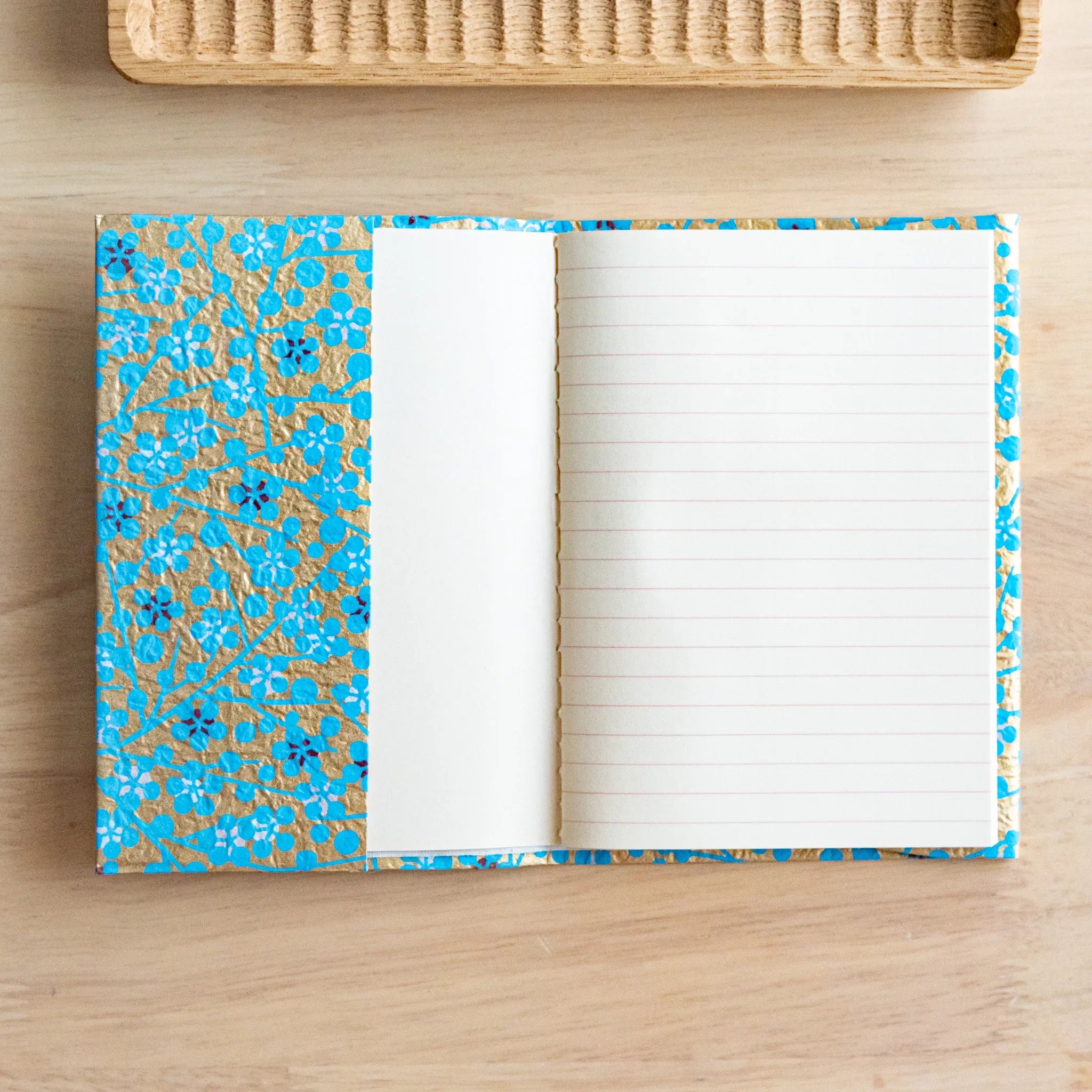 Yuzen washi book cover featuring blue floral pattern with folded presentation showing cover design detail