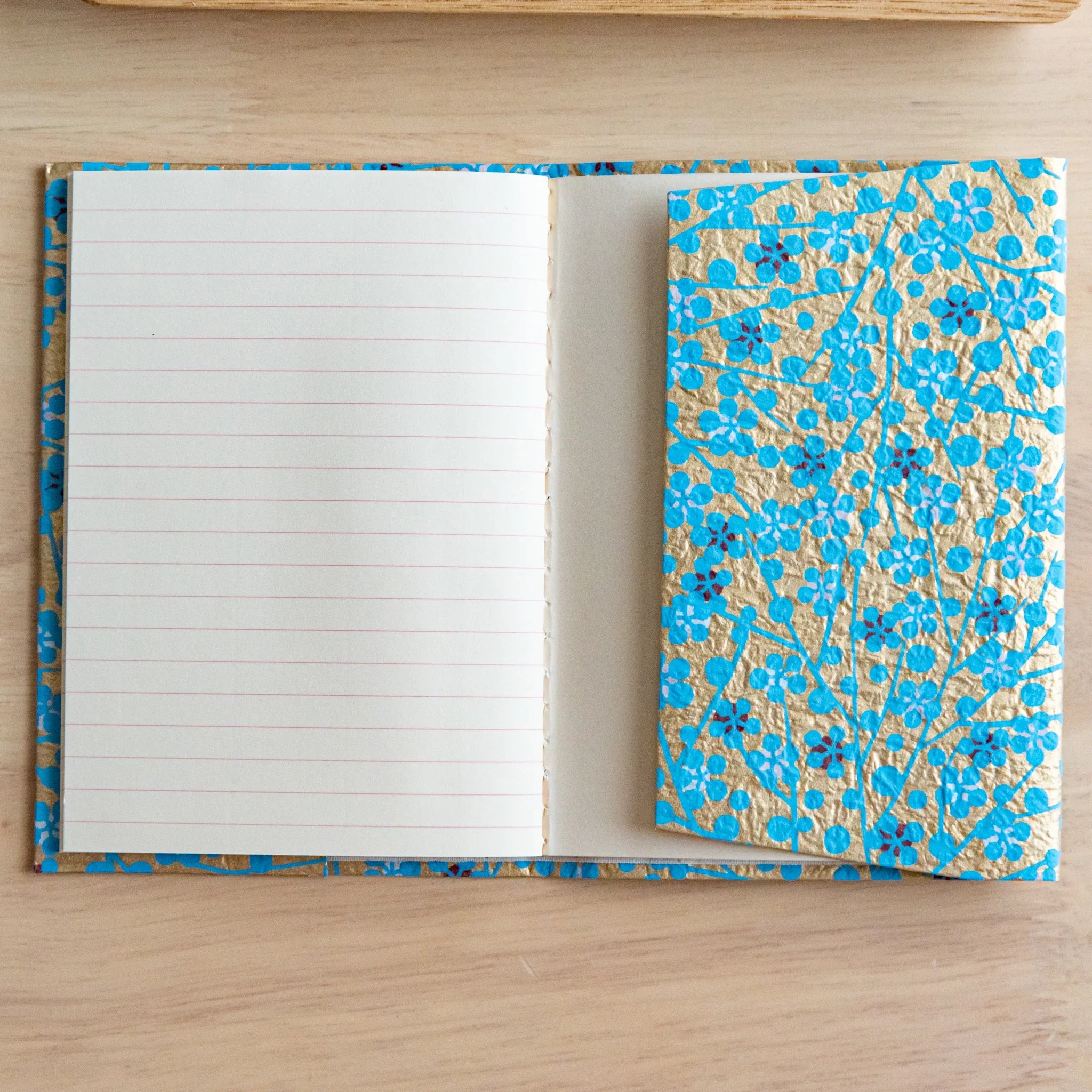 Detailed close-up of Yuzen washi book cover displaying blue flower dye pattern and traditional paper texture