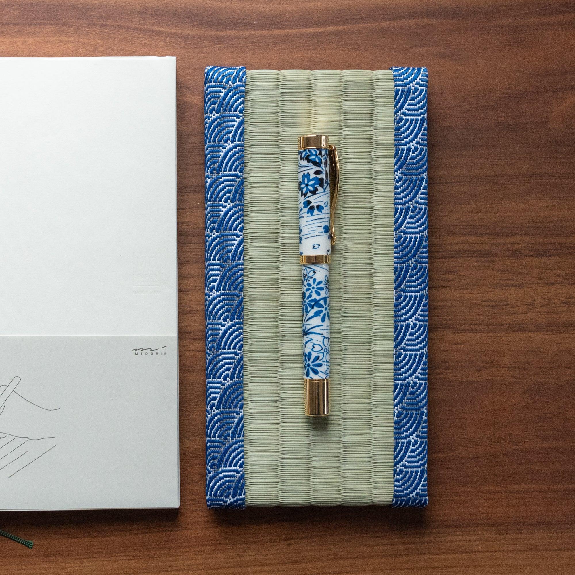 Blue Yachiyo tatami pen tray with indigo geometric pattern borders and natural woven grass surface showing product quality