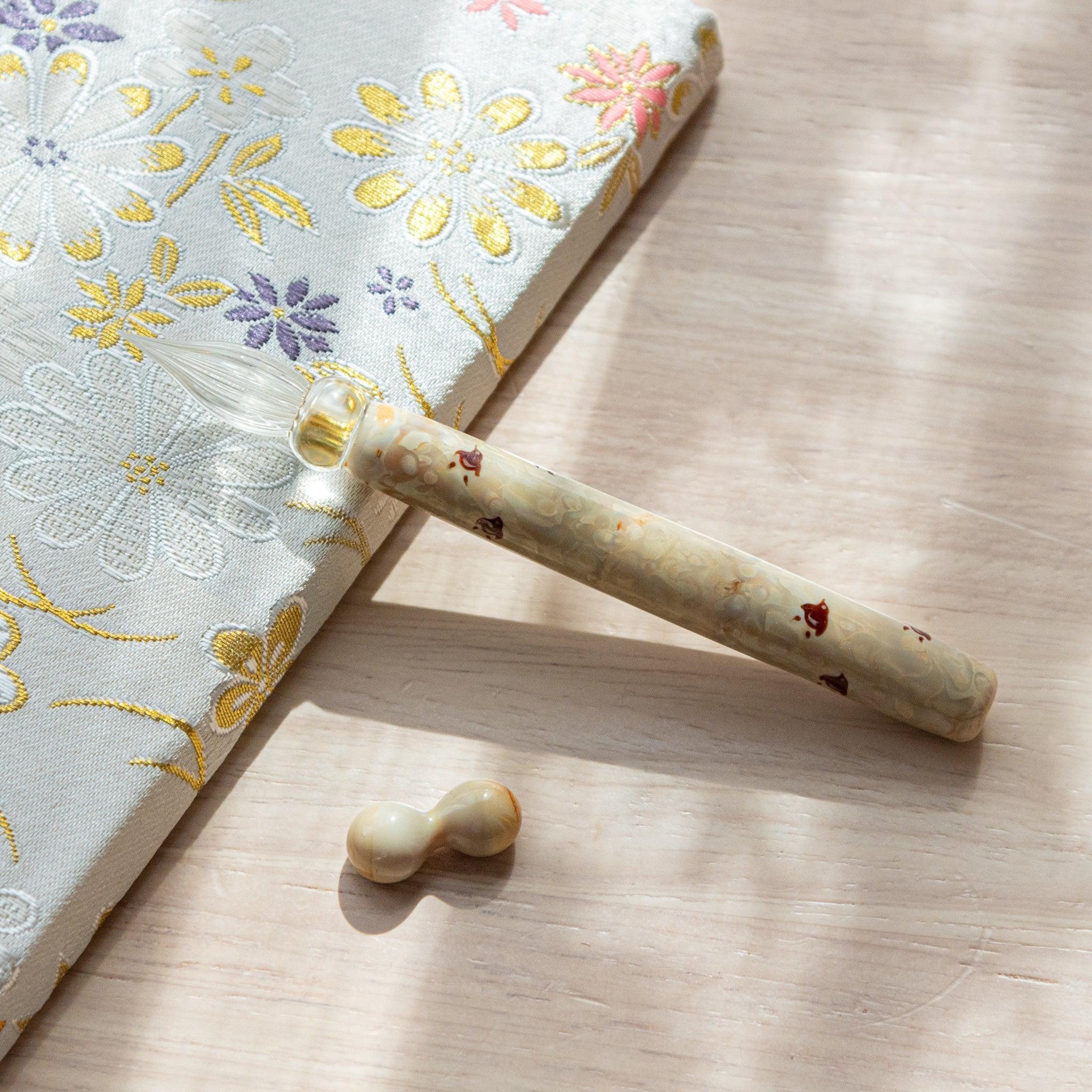 Chidori ivory glass dip pen showing chidori motif on transparent glass barrel with matching pen rest accessory