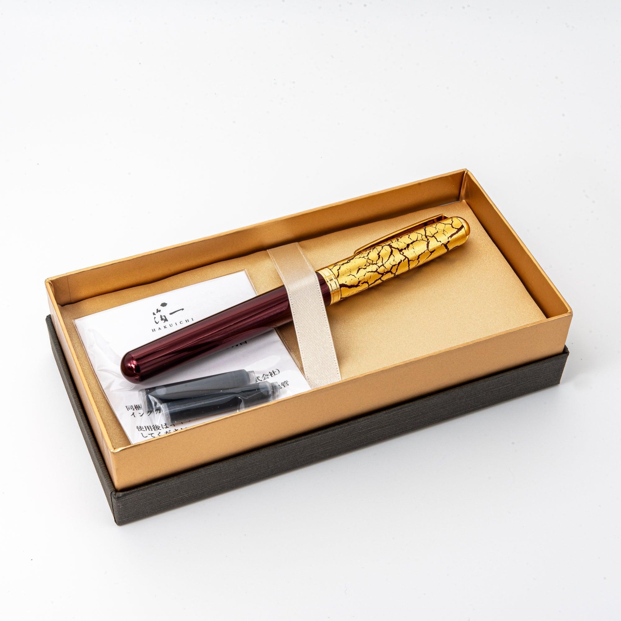 Dark wine red fountain pen with prominent gold leaf crack pattern design detail on lacquer barrel surface