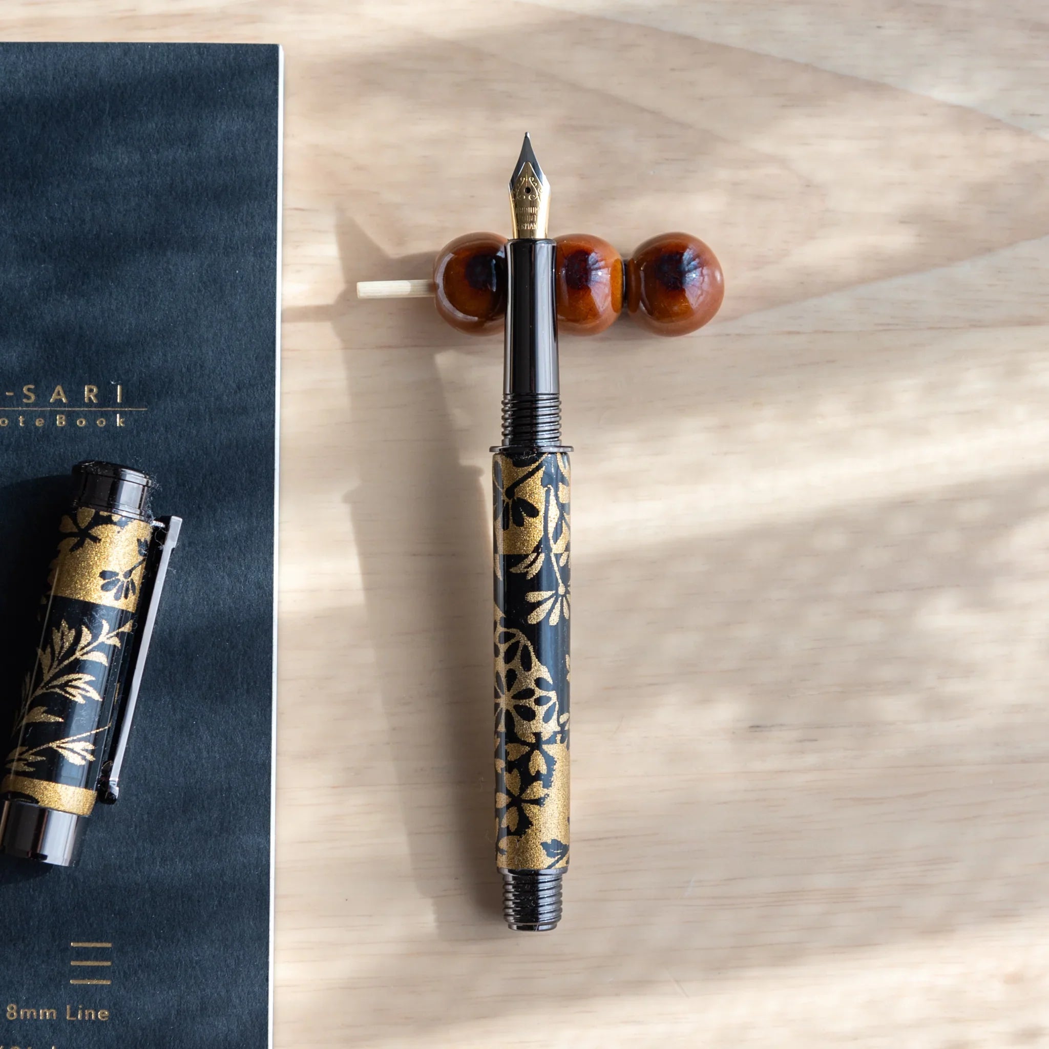 Purple and white dango handcrafted pen rest with three polished spherical beads and purple decorative ribbon detail