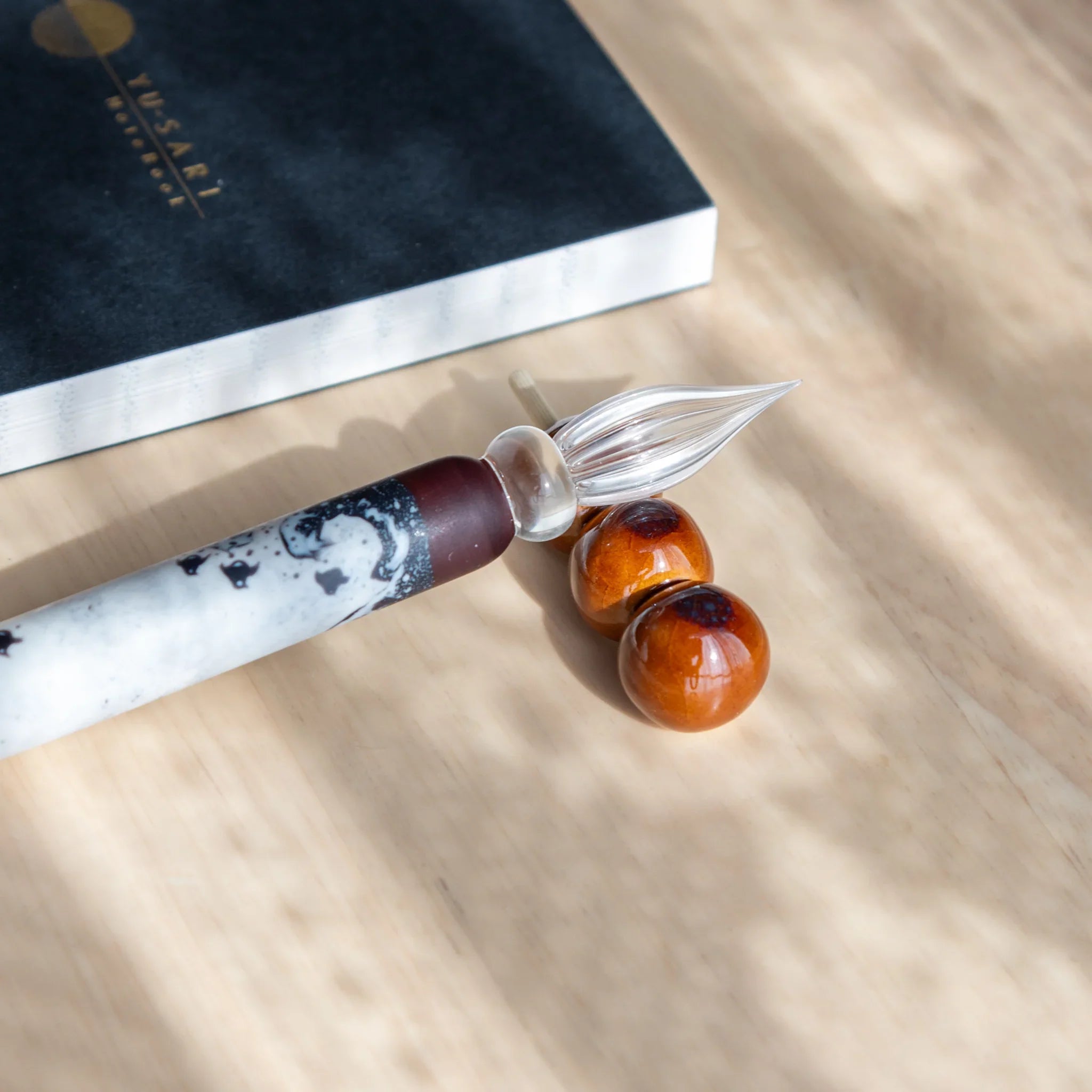 Brown, white and green dango pen rest with three sphere beads in warm natural earth tone palette finish display
