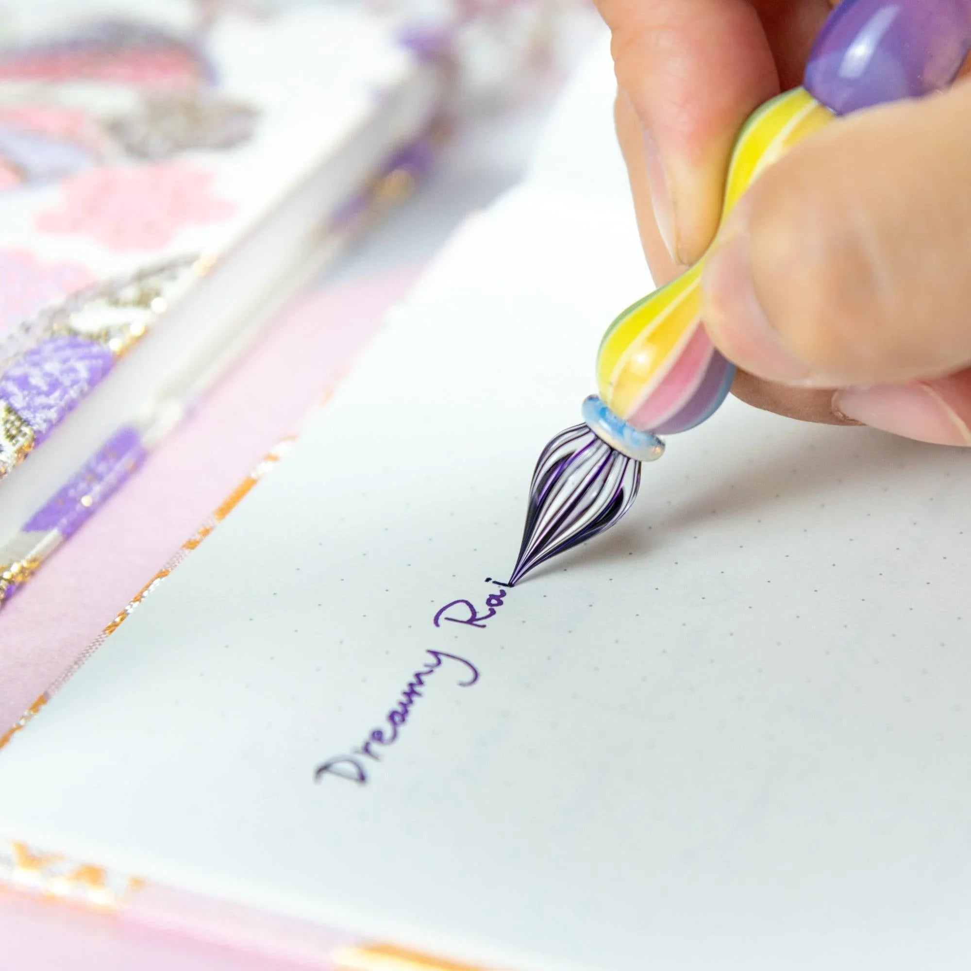 Overhead flat lay of Dreamy Rainbow Rose glass balloon pen on white background surface for calligraphy and ink illustratio