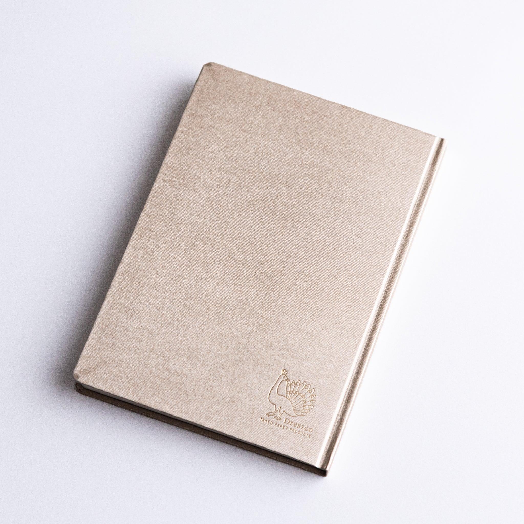 Spine and edge view of Dressco Bank Ledger Paper A6 notebook showing the sewn binding and layered paper edges