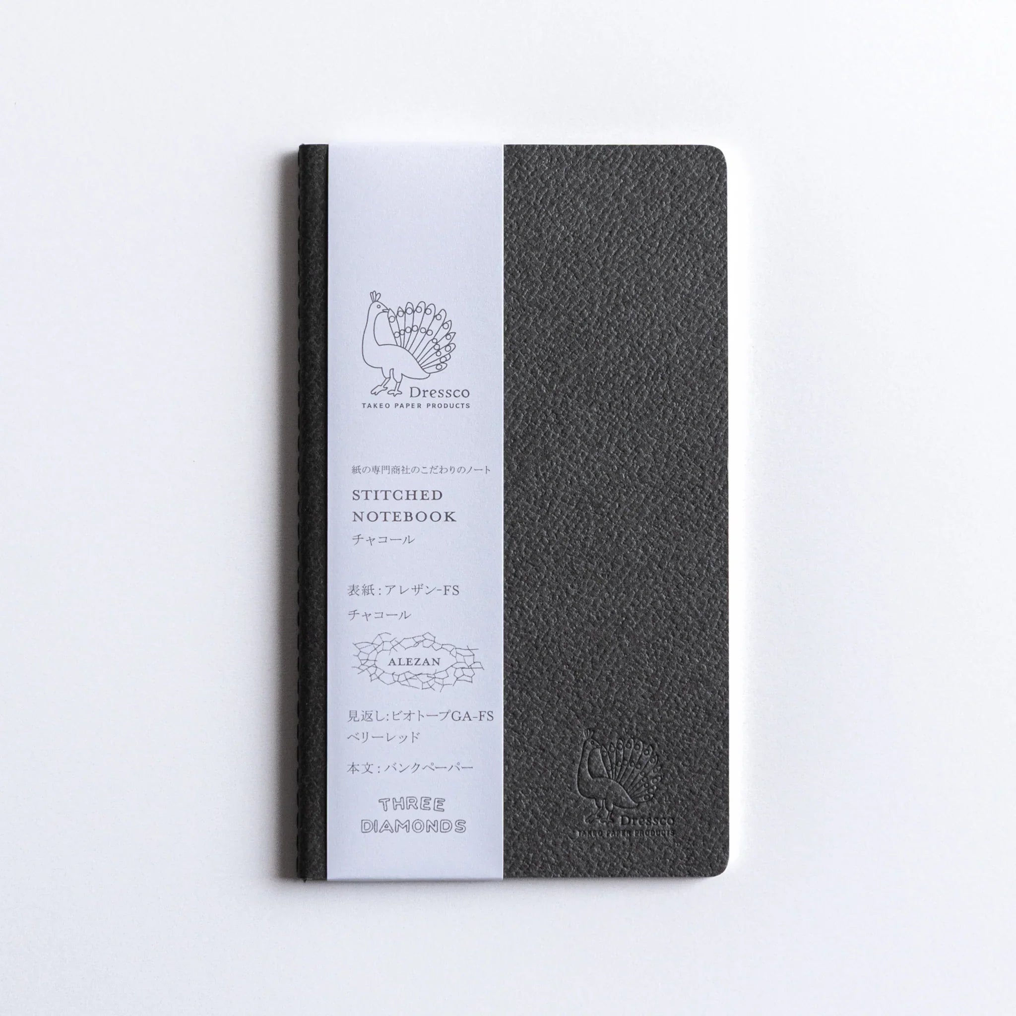 White product information wrapper on charcoal Dressco A6 notebook with embossed logo design clearly visible on cover