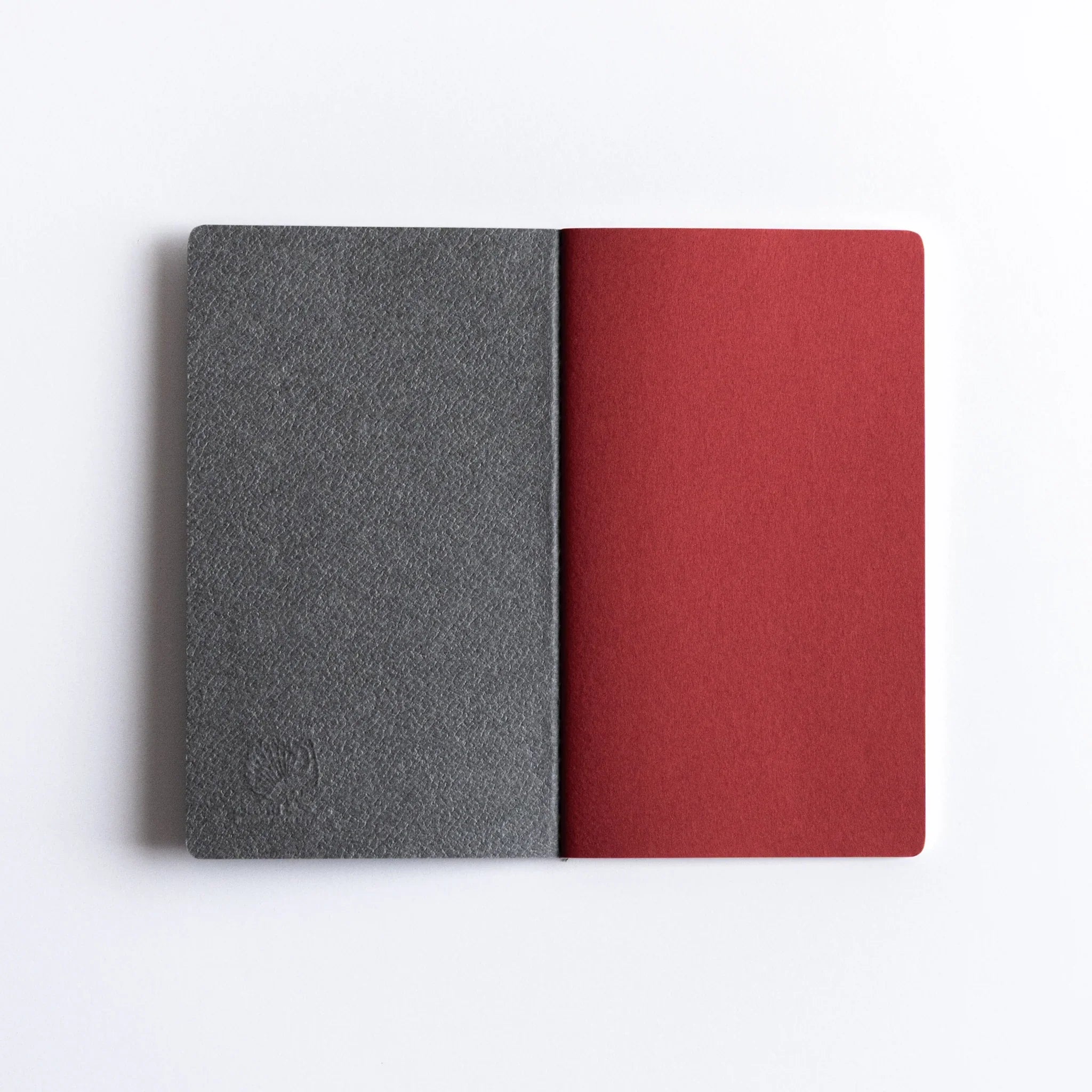 Two-color Dressco A6 notebooks with charcoal and orange fabric covers stacked together showing size and construction