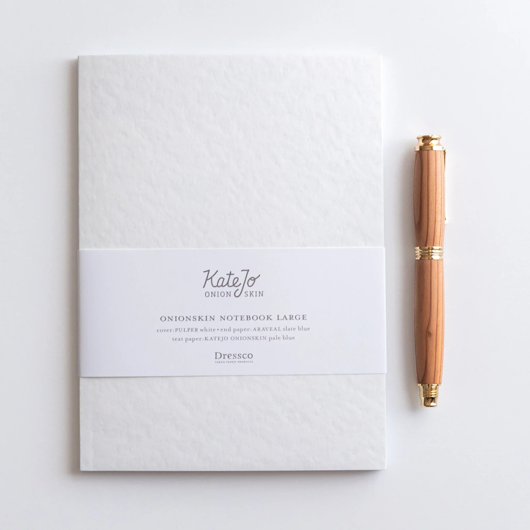 Flat lay of Dressco Blue onion skin notebook with coordinating stationery items and pen for writing and personal correspon