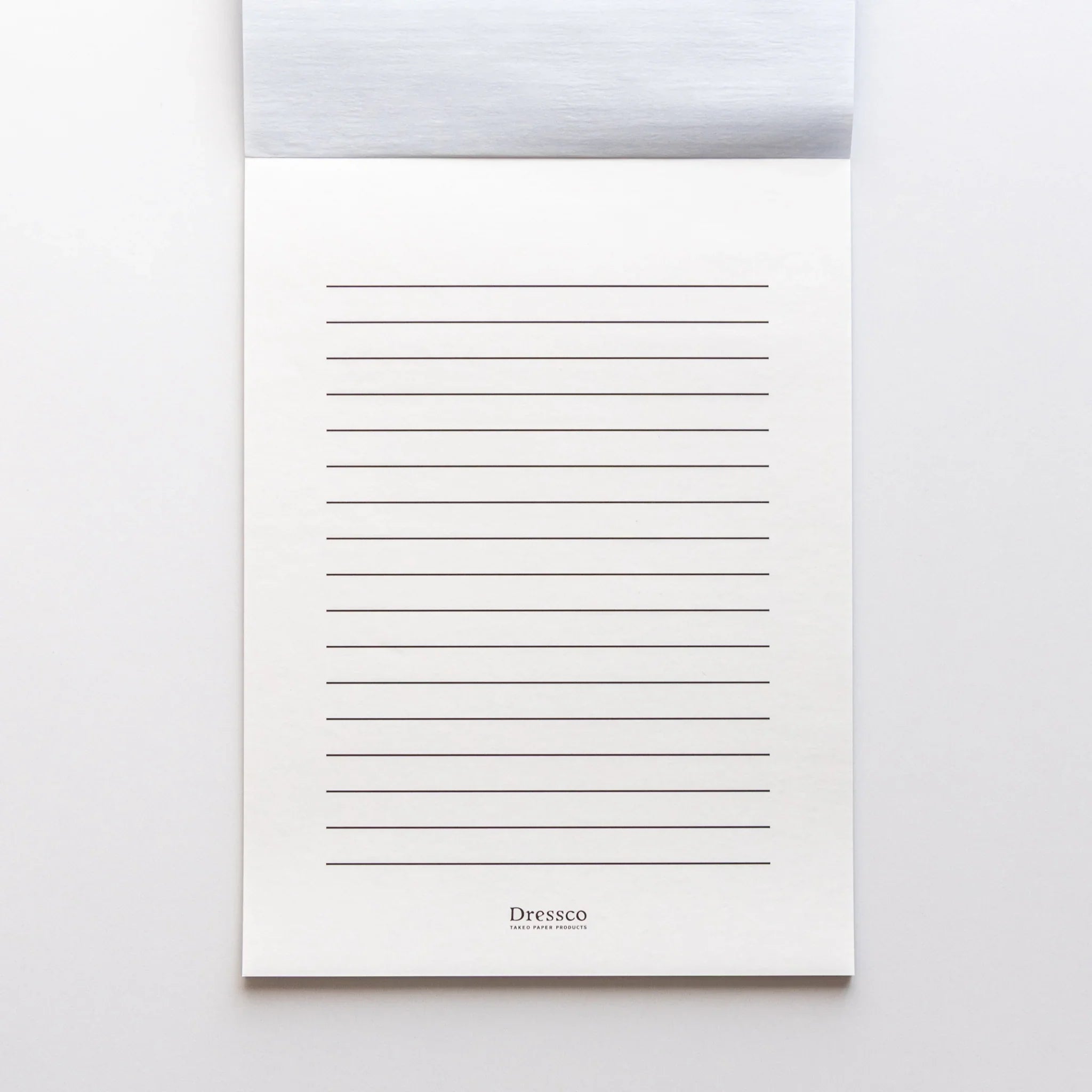 Dressco Blue writing pad closed flat on wooden surface showing overall proportions for writing and personal correspondence