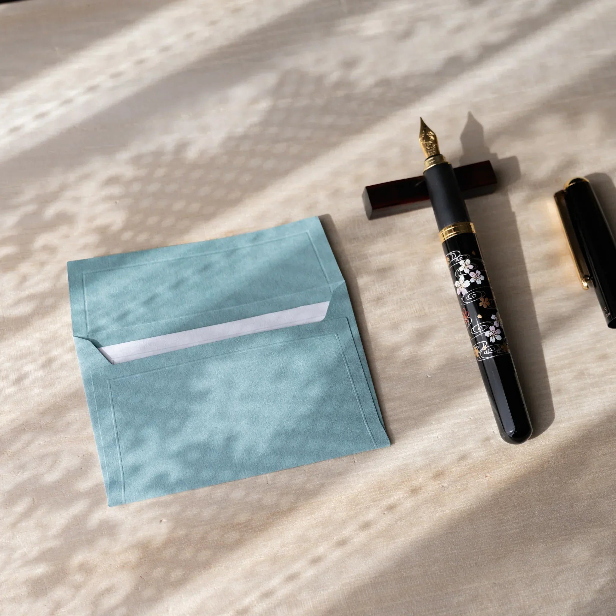 Dressco small embossed envelope set, teal shade, flat lay showing with textured                               