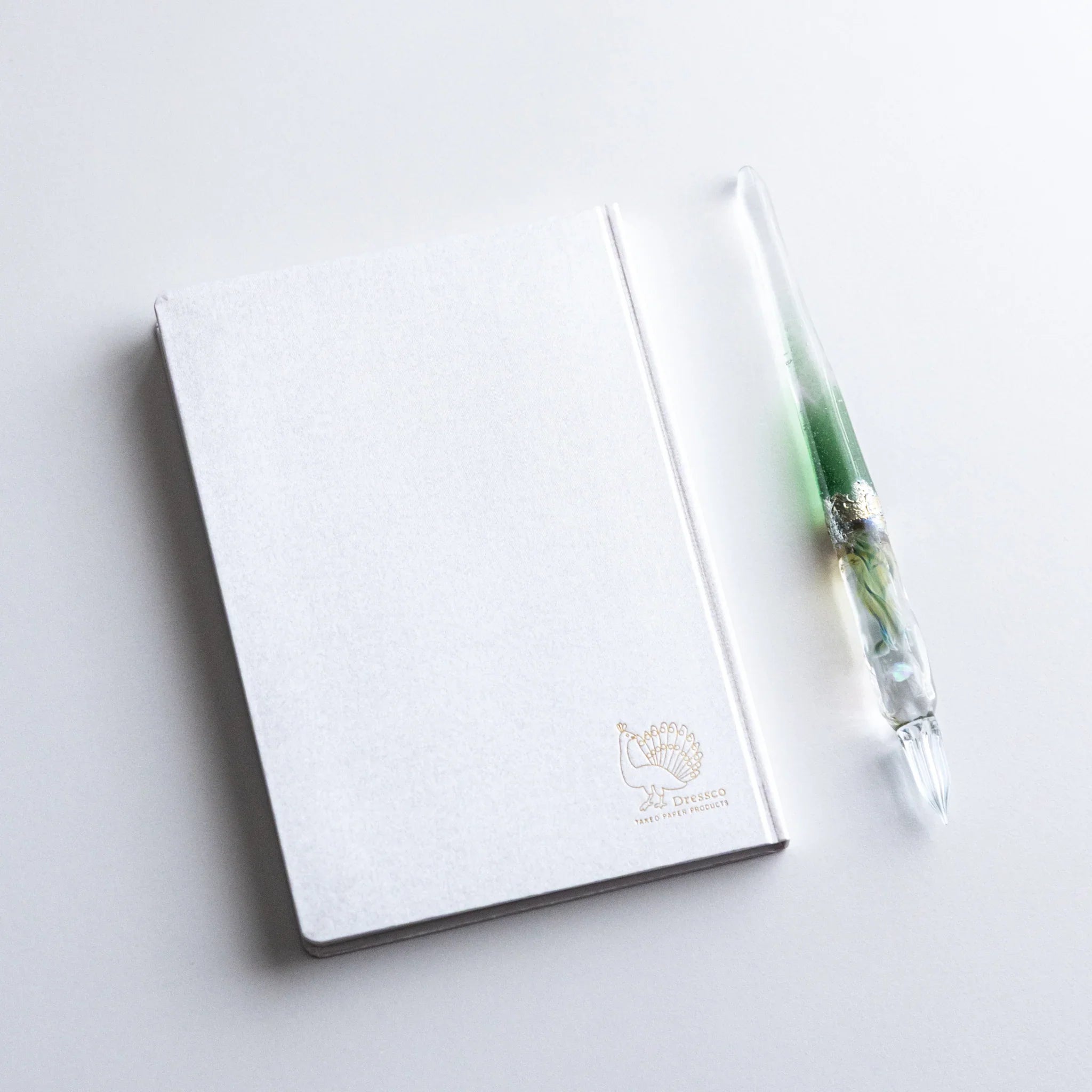 Dressco Spica Laid Bond Paper A6 notebook spine view showing the sewn binding construction and paper edge texture