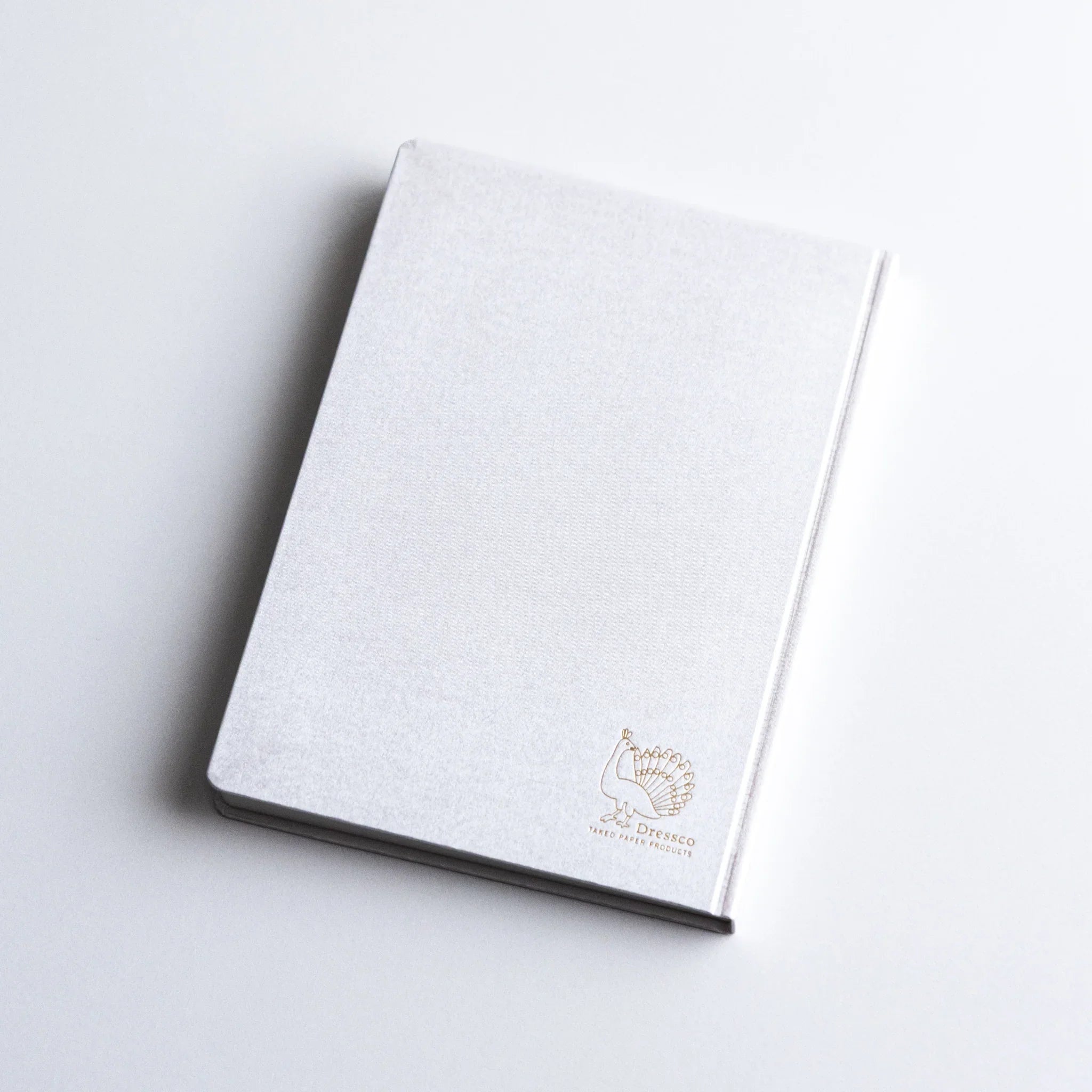 Dressco Spica Laid Bond Paper A6 notebook displayed upright at a slight angle showing cover and spine side