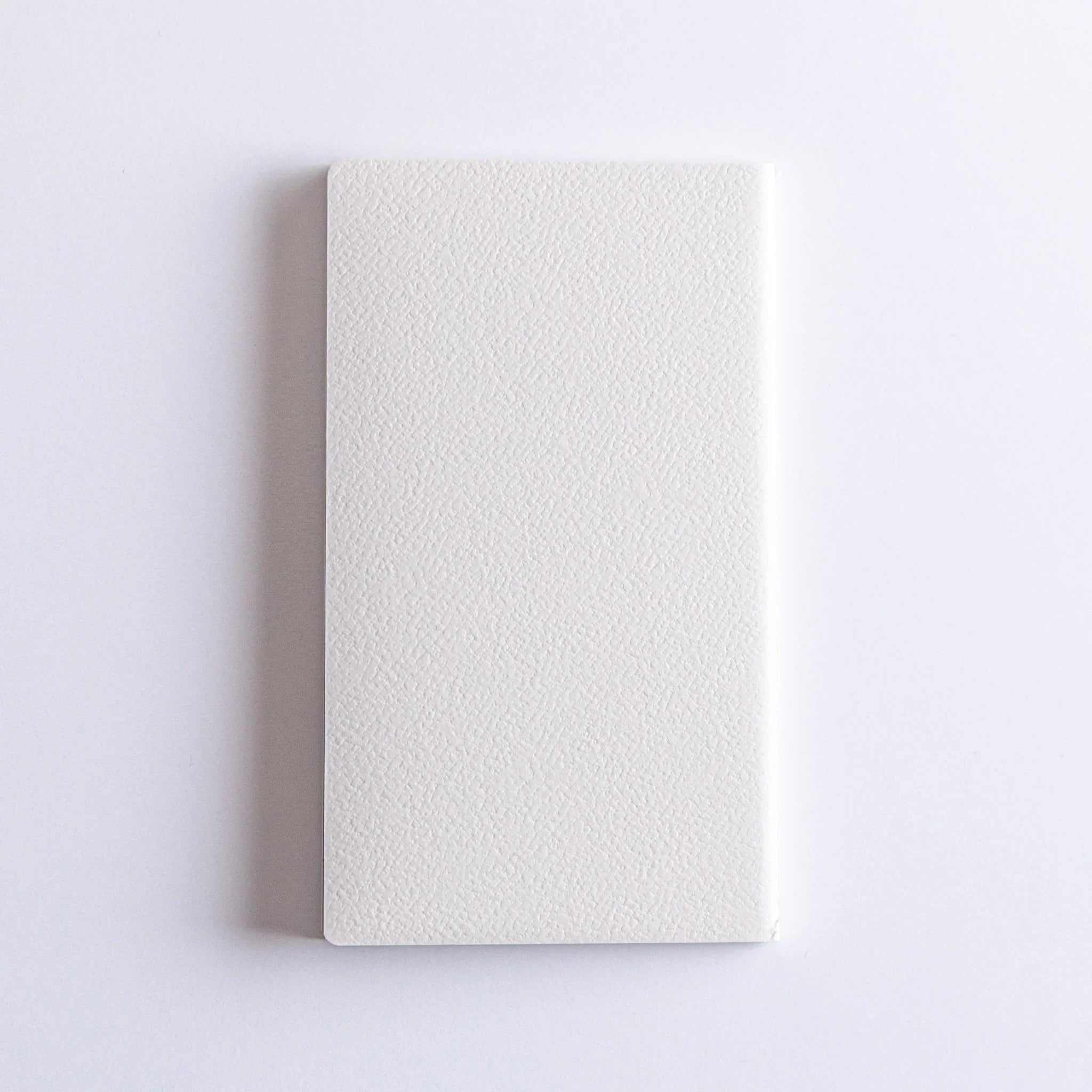 Dressco Spica Laid Bond Stitched A6 notebook displayed standing at slight angle showing cover and stitched spine