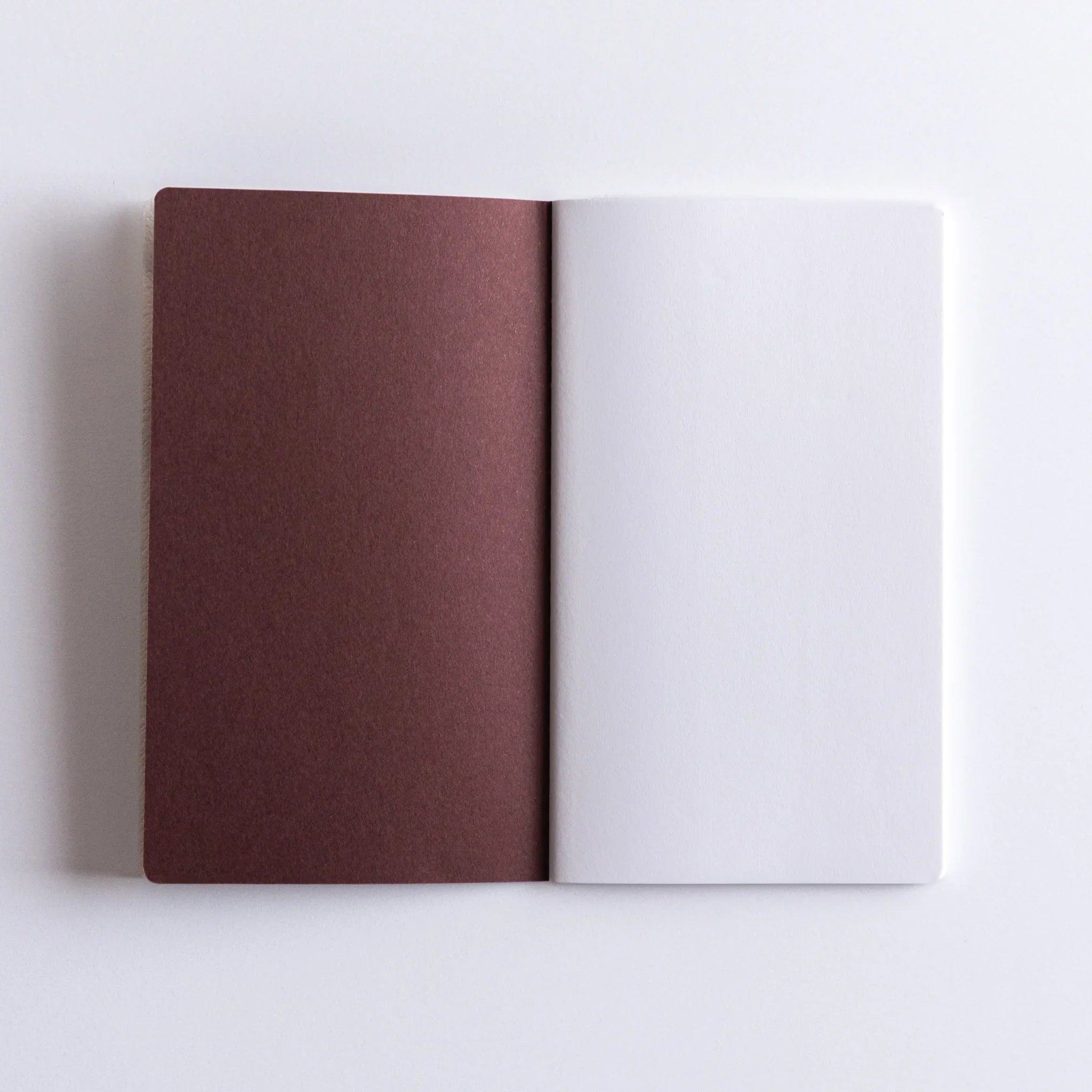 Dressco Spica Laid Bond Stitched A6 notebook angled view showing cover texture and visible stitching on the spine