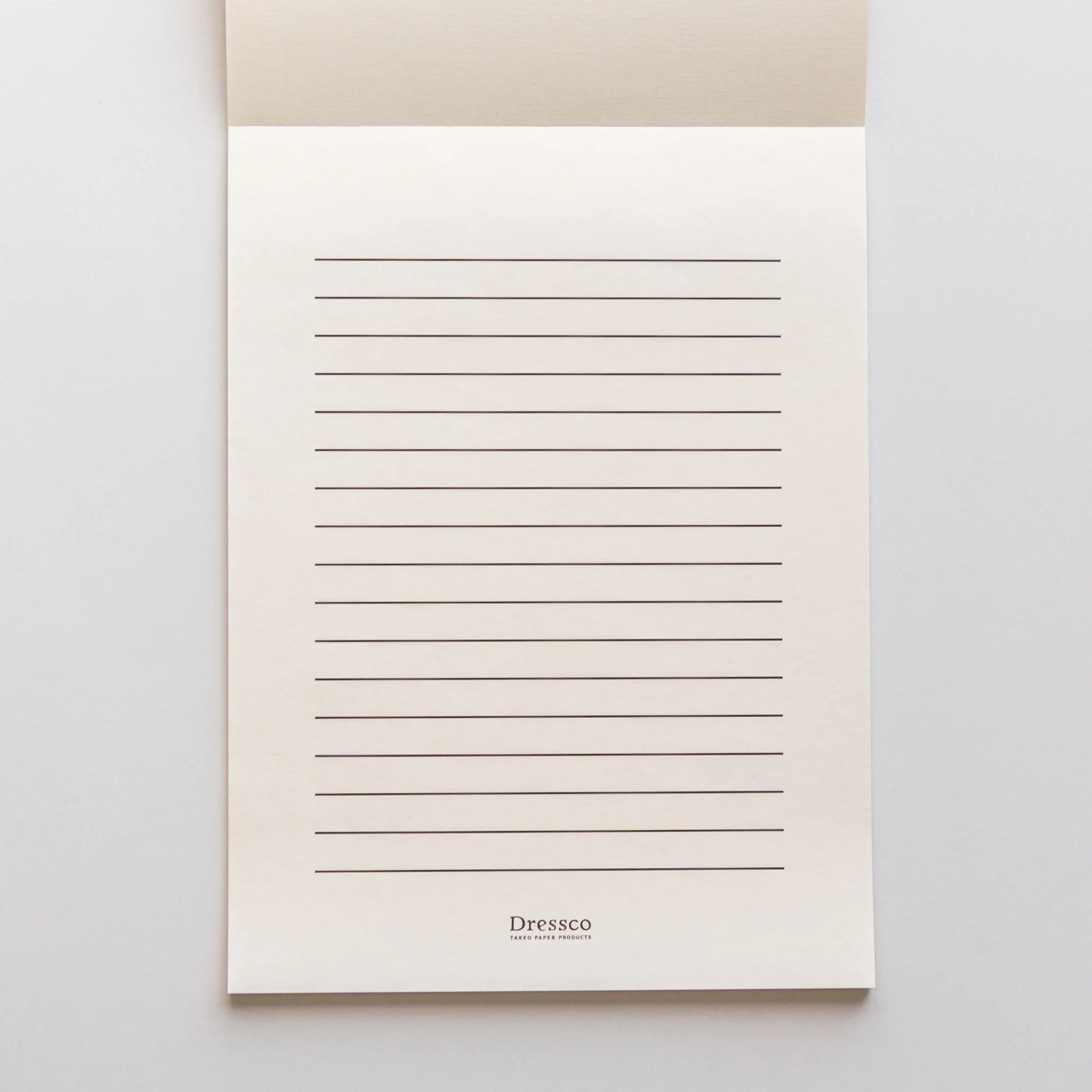Top-down view of cream Strathmore writing pad with fold and page layering clearly visible structure composition
