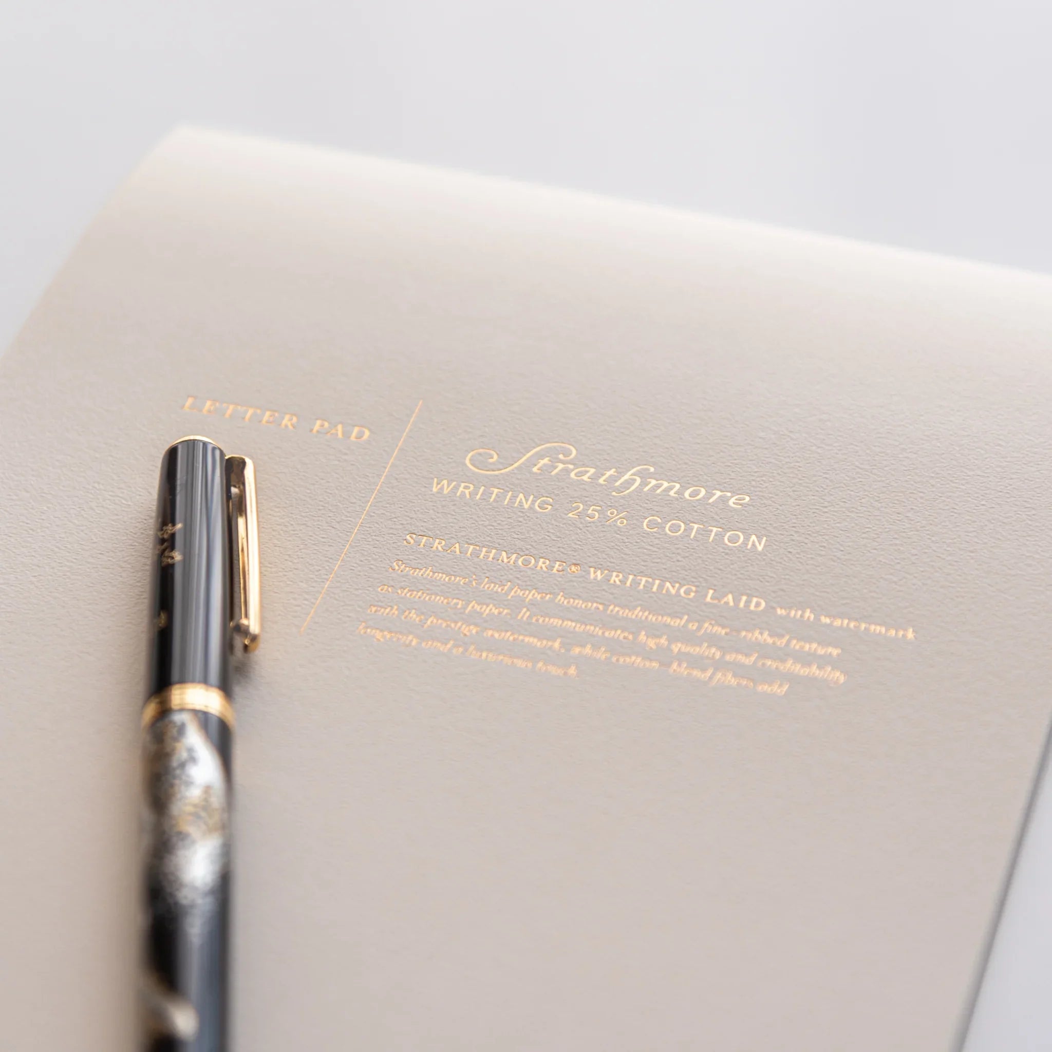 Overhead view of writing pad pages fanned showing paper quality and laid texture visible throughout composition shown
