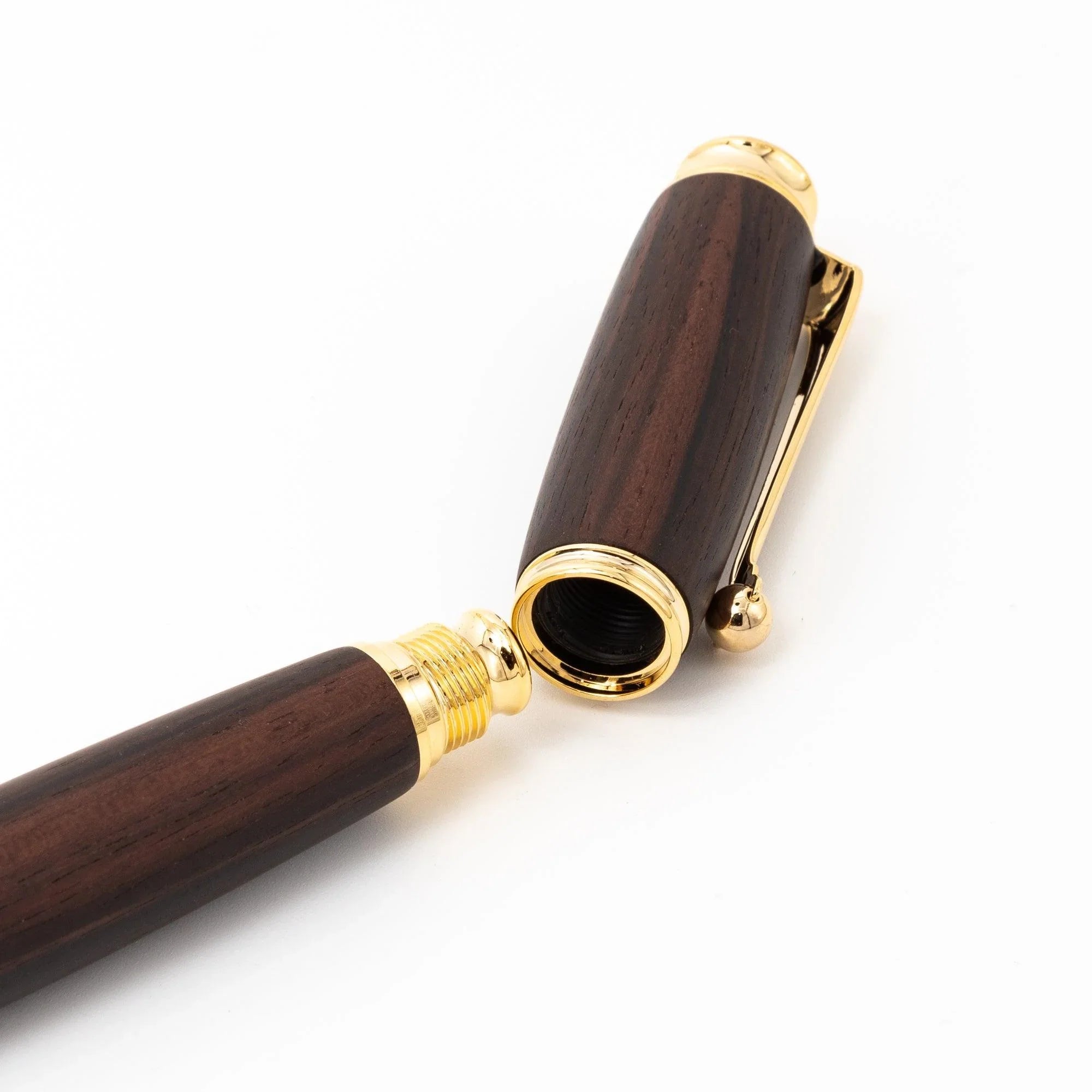 Dark ebony wood pen on cream paper showing wooden grain texture and surface finish displayed clearly