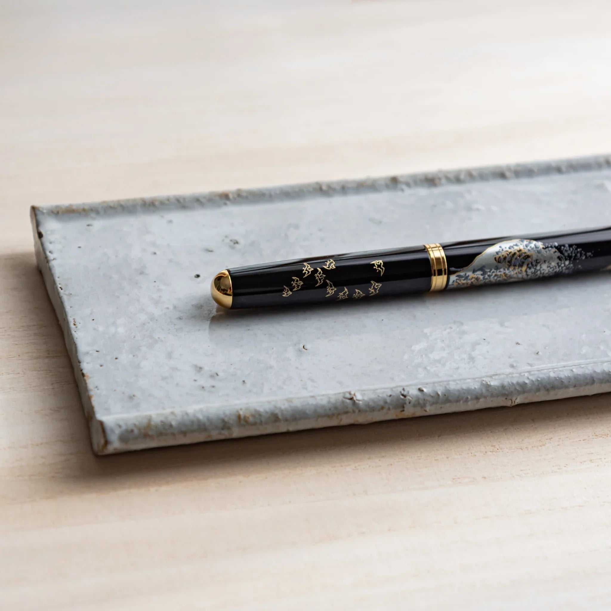 Ceramic pen tray viewed from above showing white glaze with contained writing instruments displayed clearly