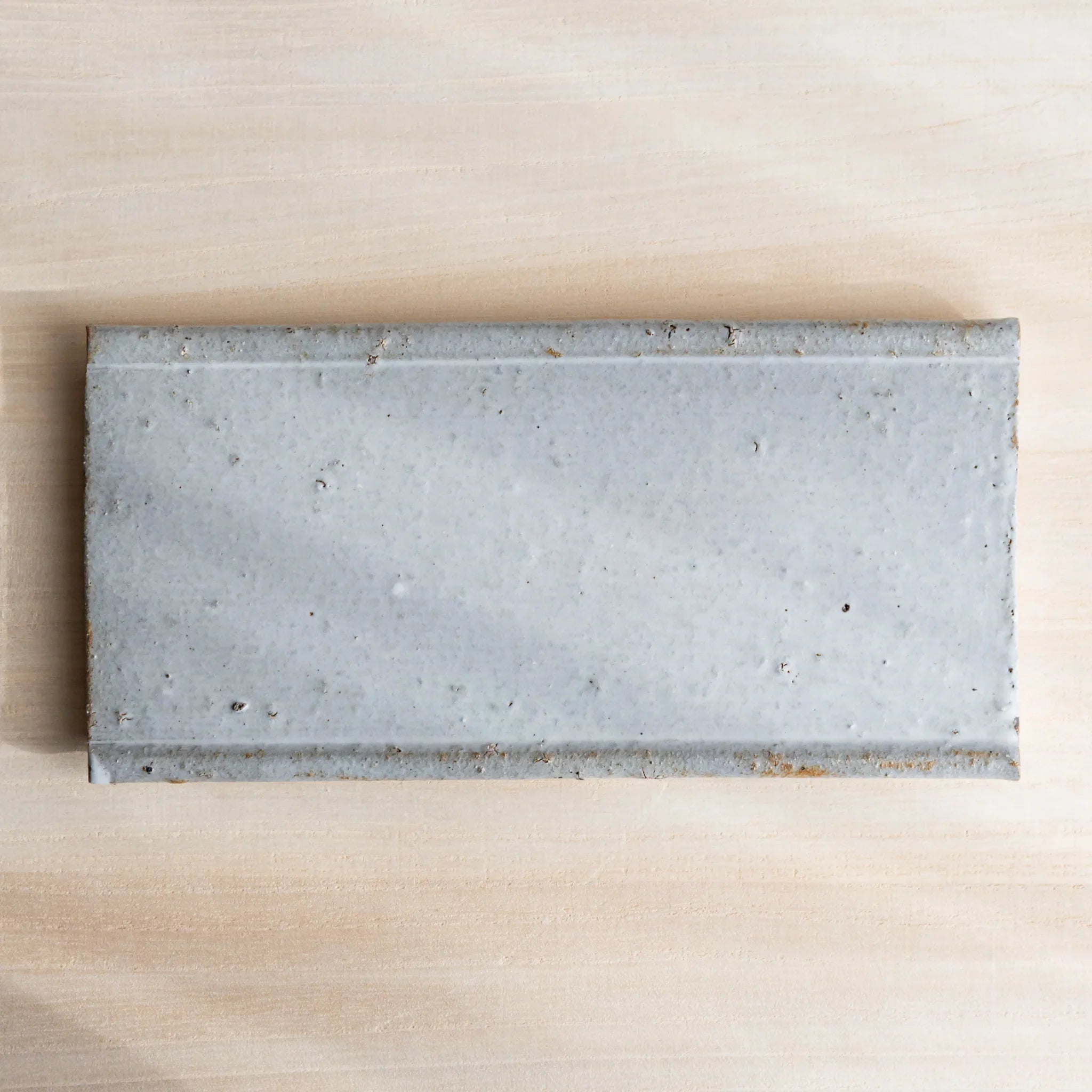 White glazed pen tray detail showing ceramic finish and subtle surface texture characteristics displayed clearly