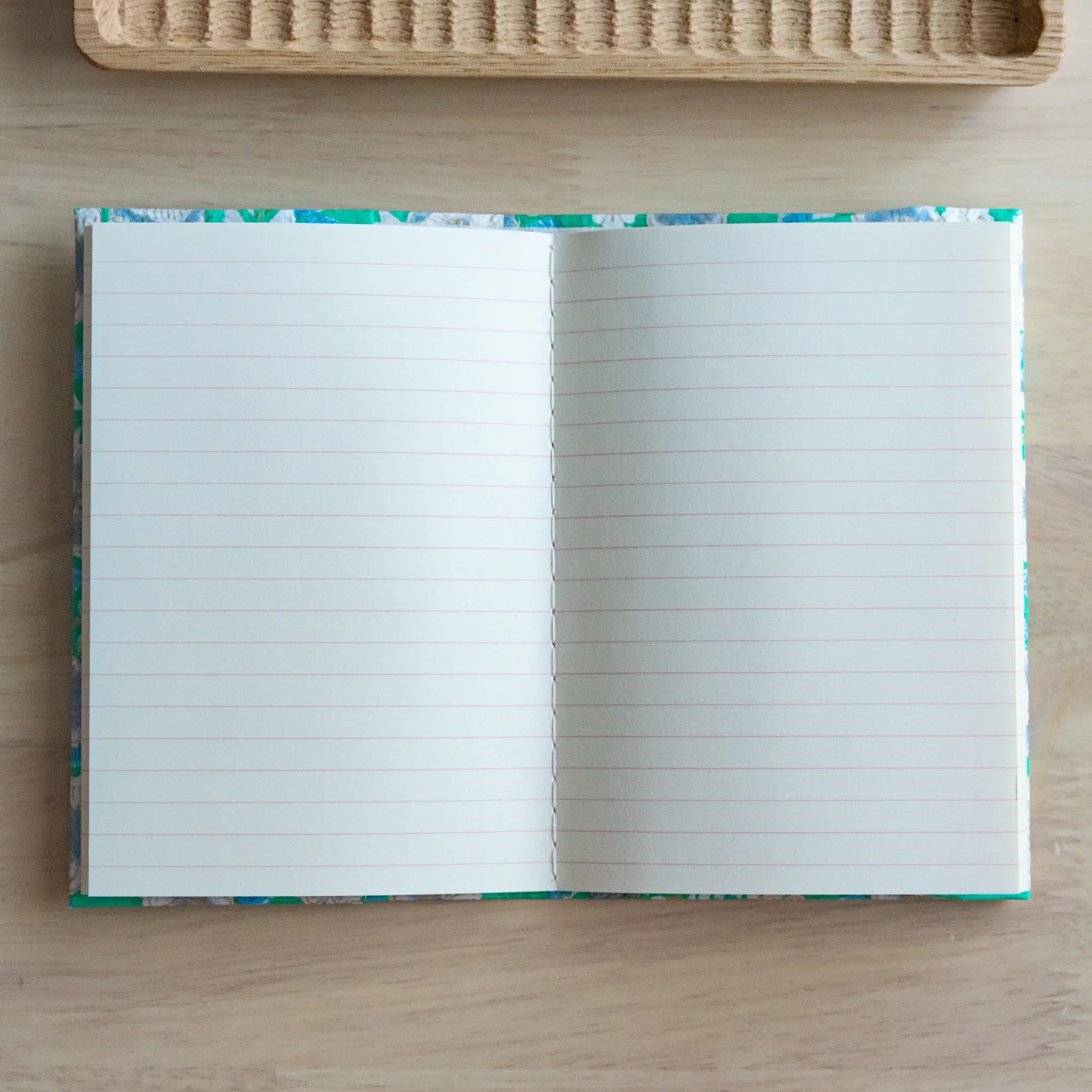 Emerald green hand-dyed yuzen washi book cover A6, angled photograph emphasizing dimensional flower embossment