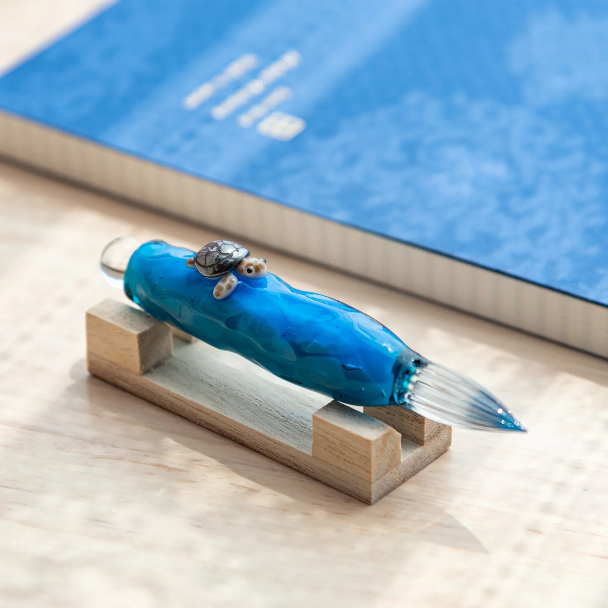 Glass dip pen featuring floating sea turtle figure enclosed inside transparent barrel, showing detailed hand-made design