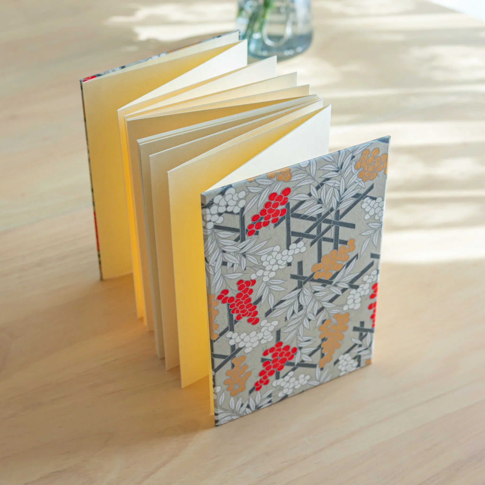 Nandina Goshuincho opened flat showing interior pages and traditional red berry leaf pattern displayed clearly