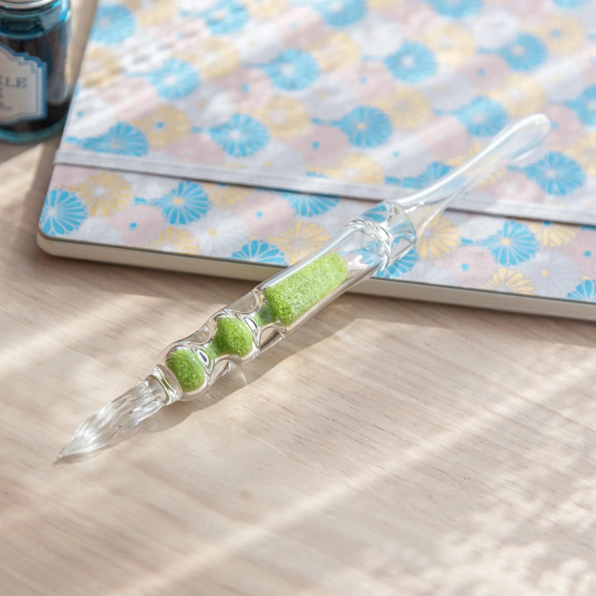 Fresh Green Hourglass Glass Dip Pen detail view showing emerald-green toned glass bulbs in hourglass barrel with nib