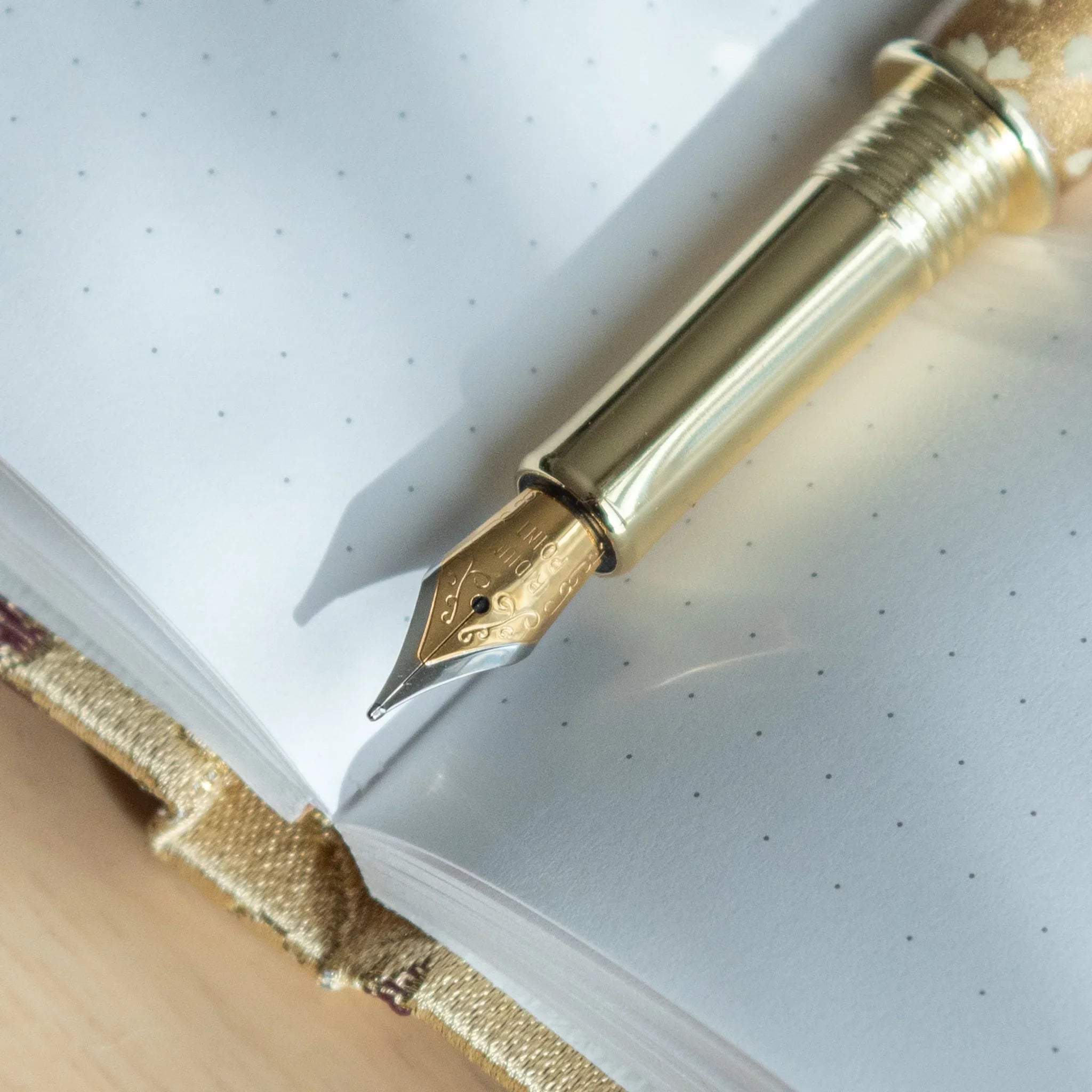 Gold Sakura Mino washi fountain pen displaying small botanical flower pattern with shimmering gold elements nib
