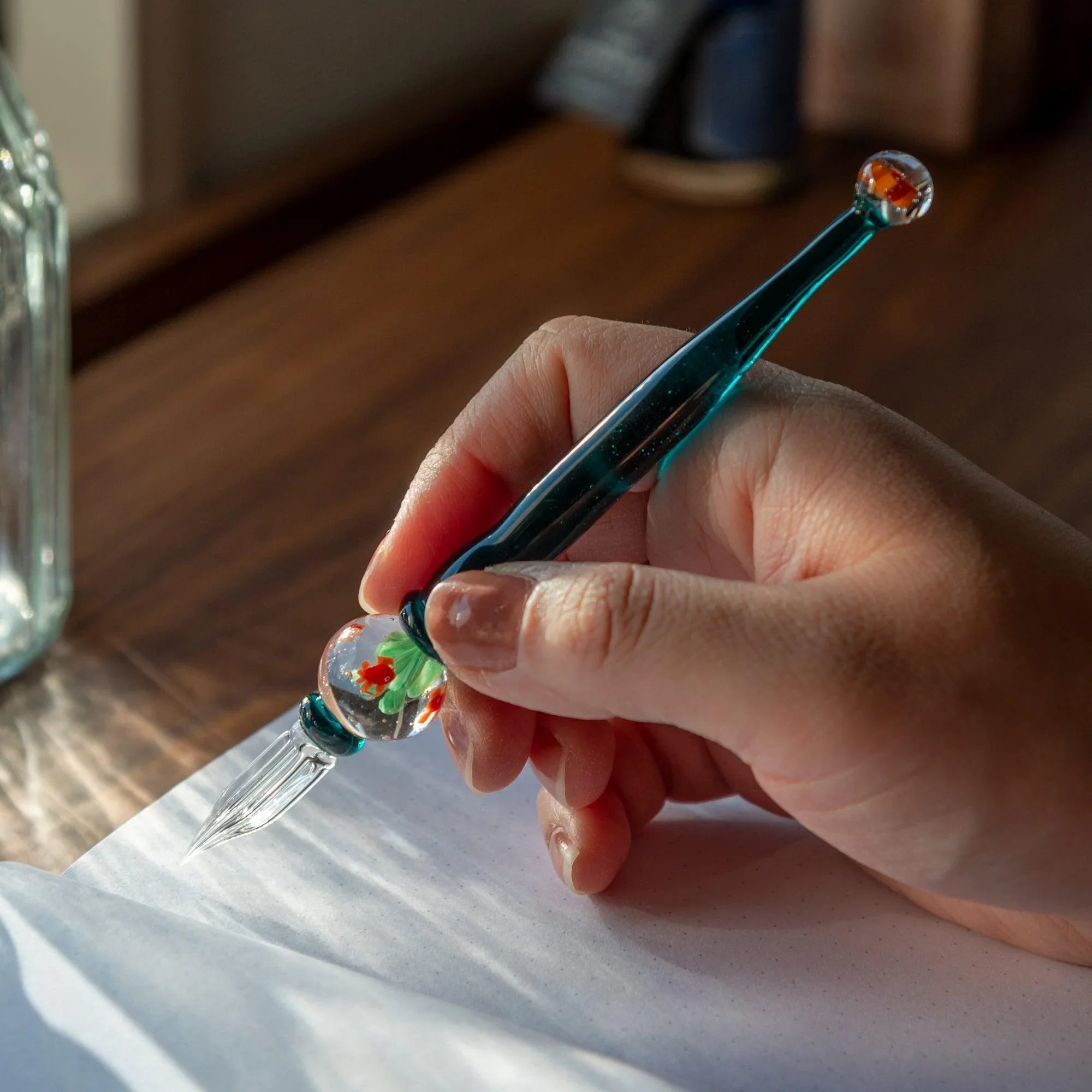 Japanese glass dip pen with transparent aquarium barrel section displaying orange goldfish and aquatic plants