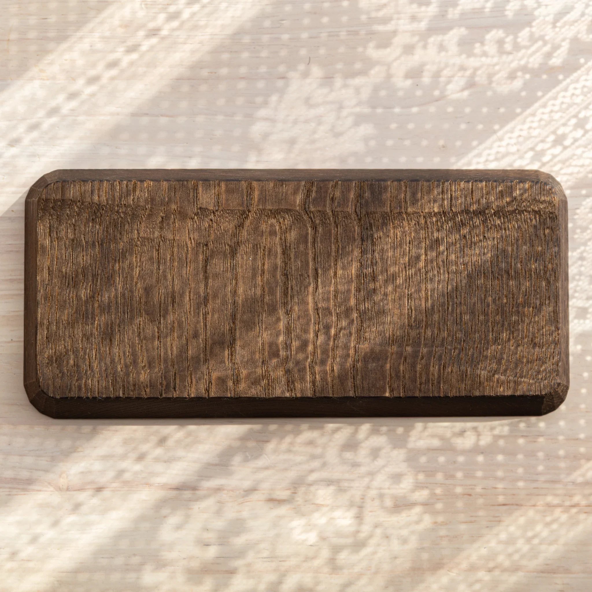 Light wood pen tray with parallel groove carving visible throughout displayed clearly with ceramic finish