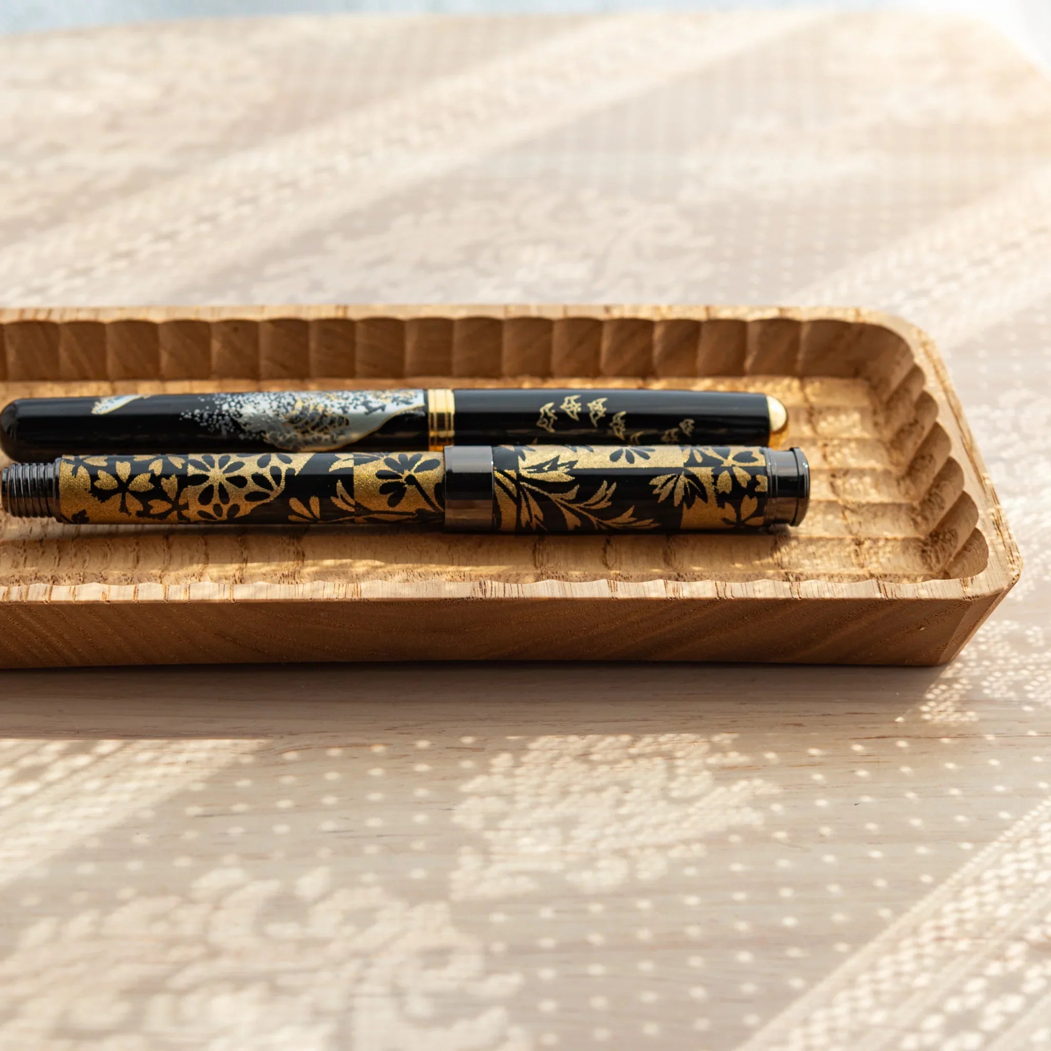 Slim pen tray viewed from above showing multiple hand-carved groove compartments displayed clearly composition