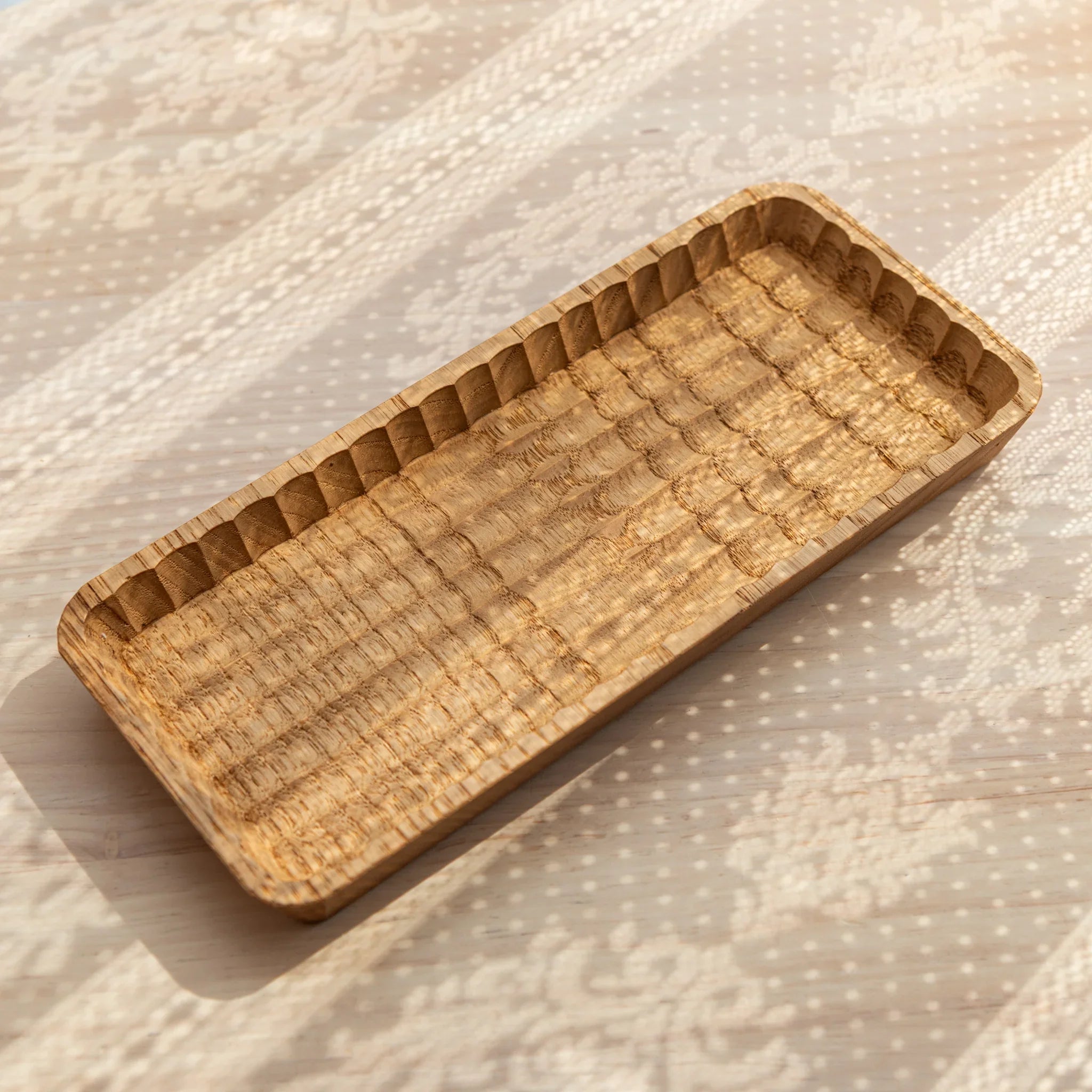 Light wood Wagatabon tray with two pens positioned in hand-carved grooves displayed clearly composition