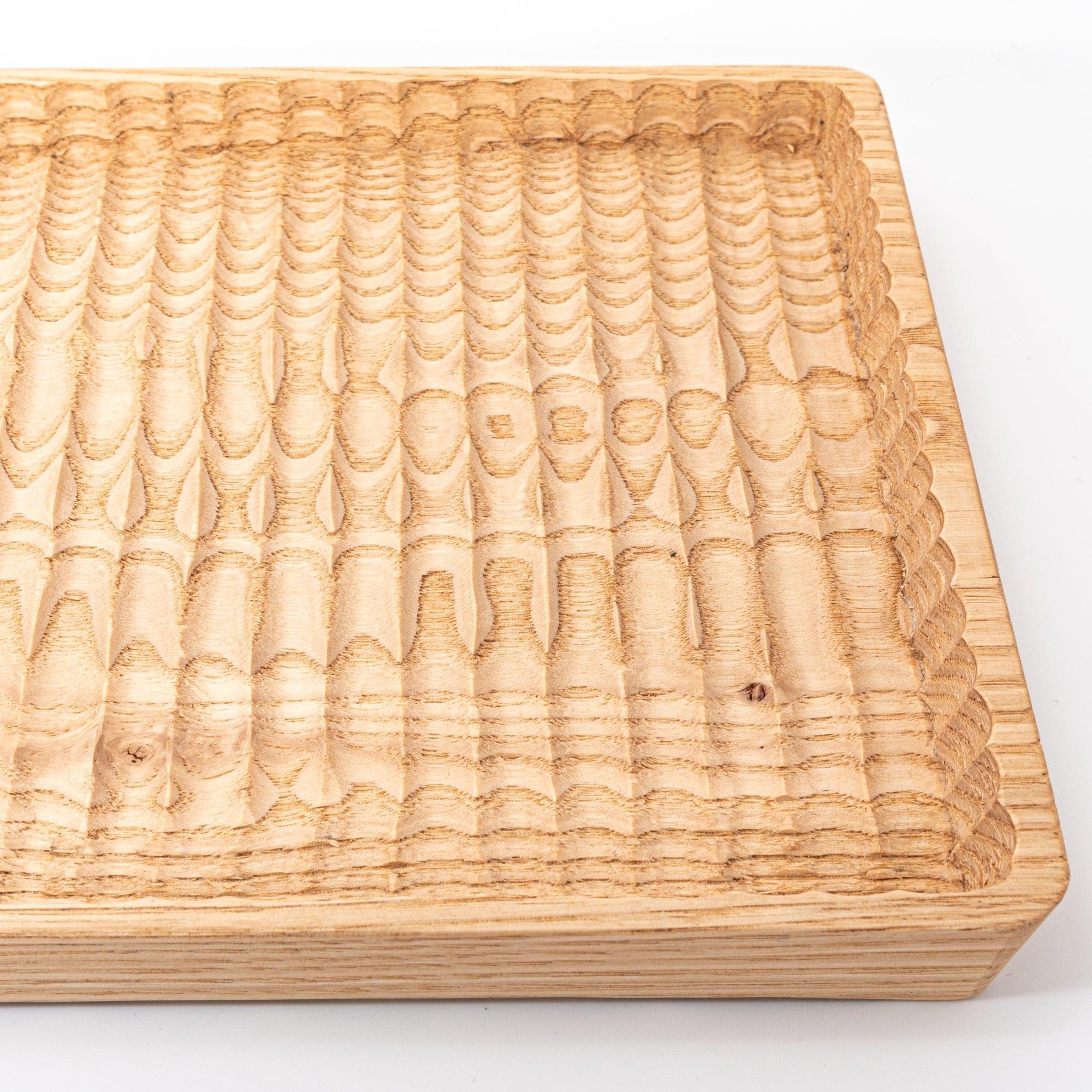 Wagatabon tray from angled view displaying carved channels and three pens positioned in slots with clear visibility of