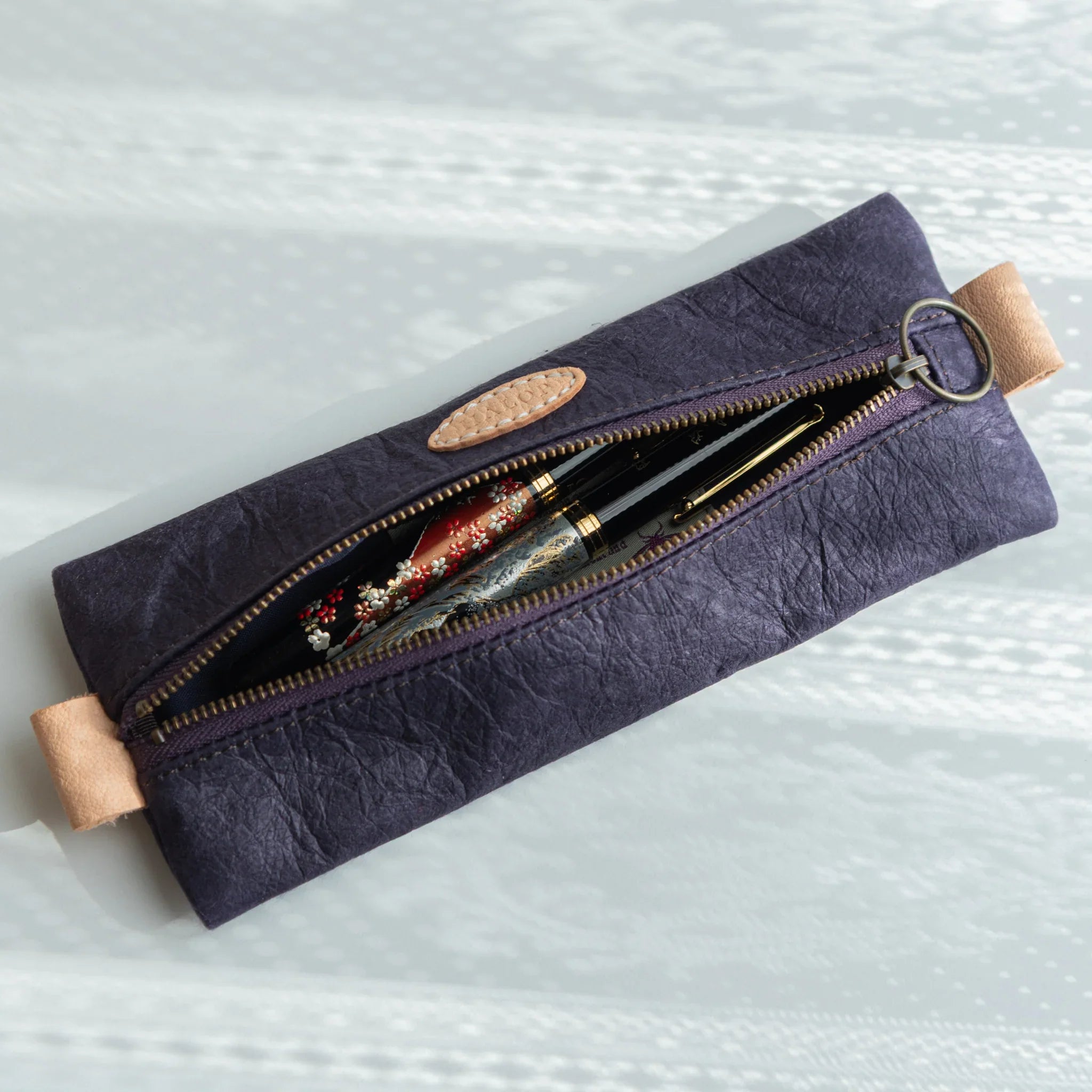 Handcrafted purple pen case showing interior structure and pen compartments displayed clearly composition