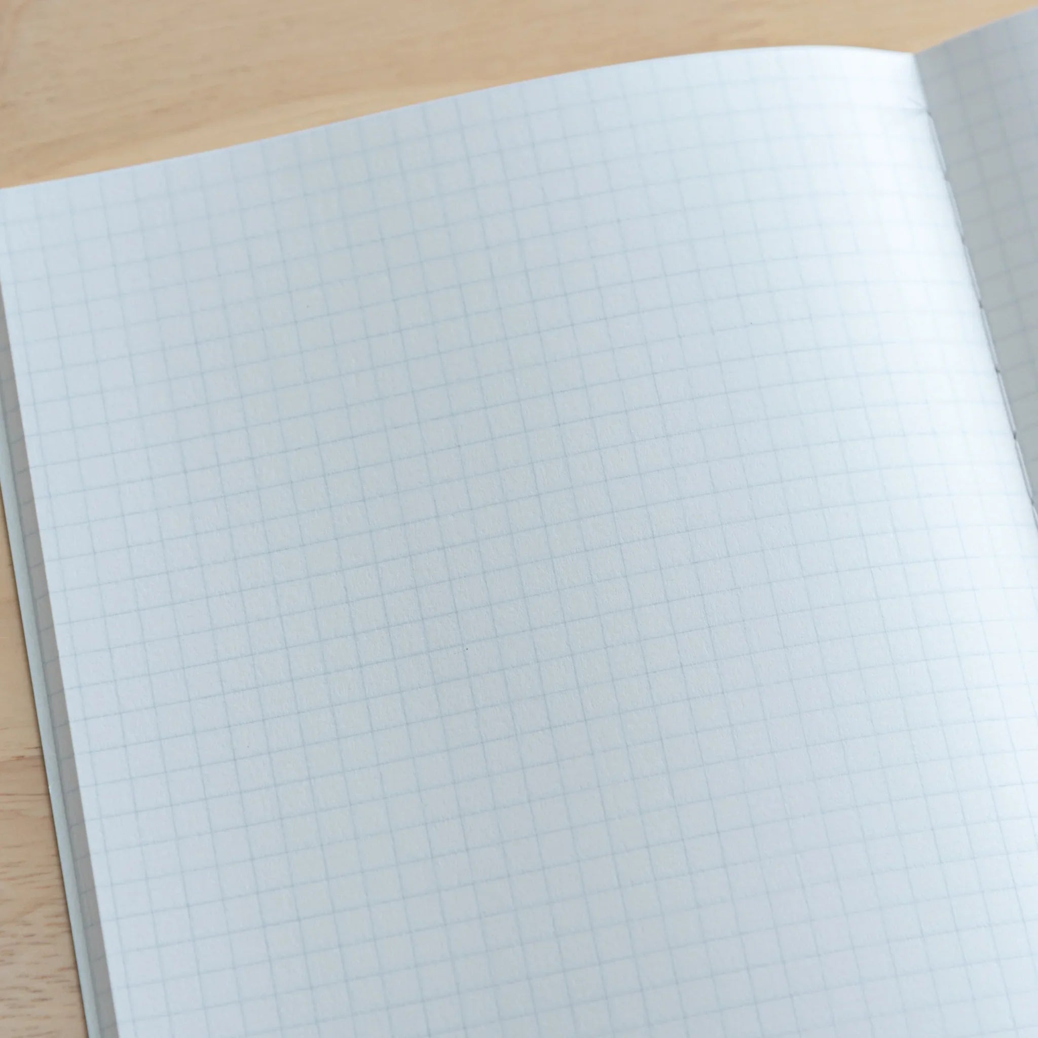Hello Kitty Tsubame Foold Notebook Grid A5 displayed at angle revealing paper thickness and binding quality detail