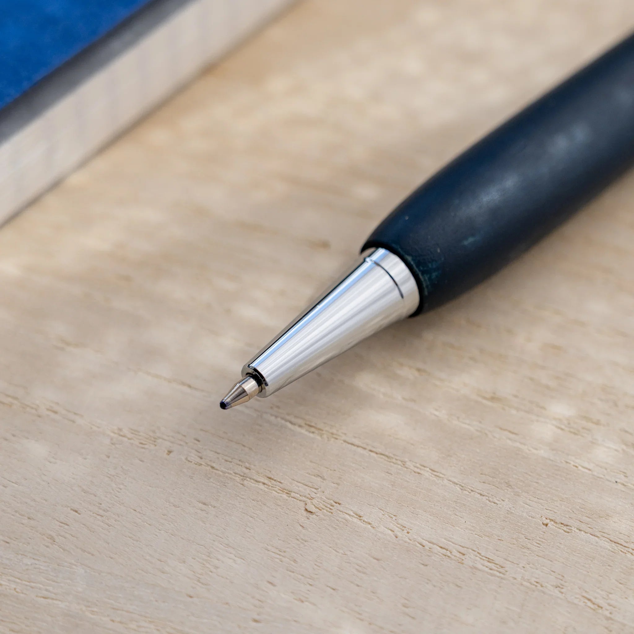 Indigo blue horse chestnut wood urushi ballpoint pen, close-up of silver cone tip and writing point, Japanese wood