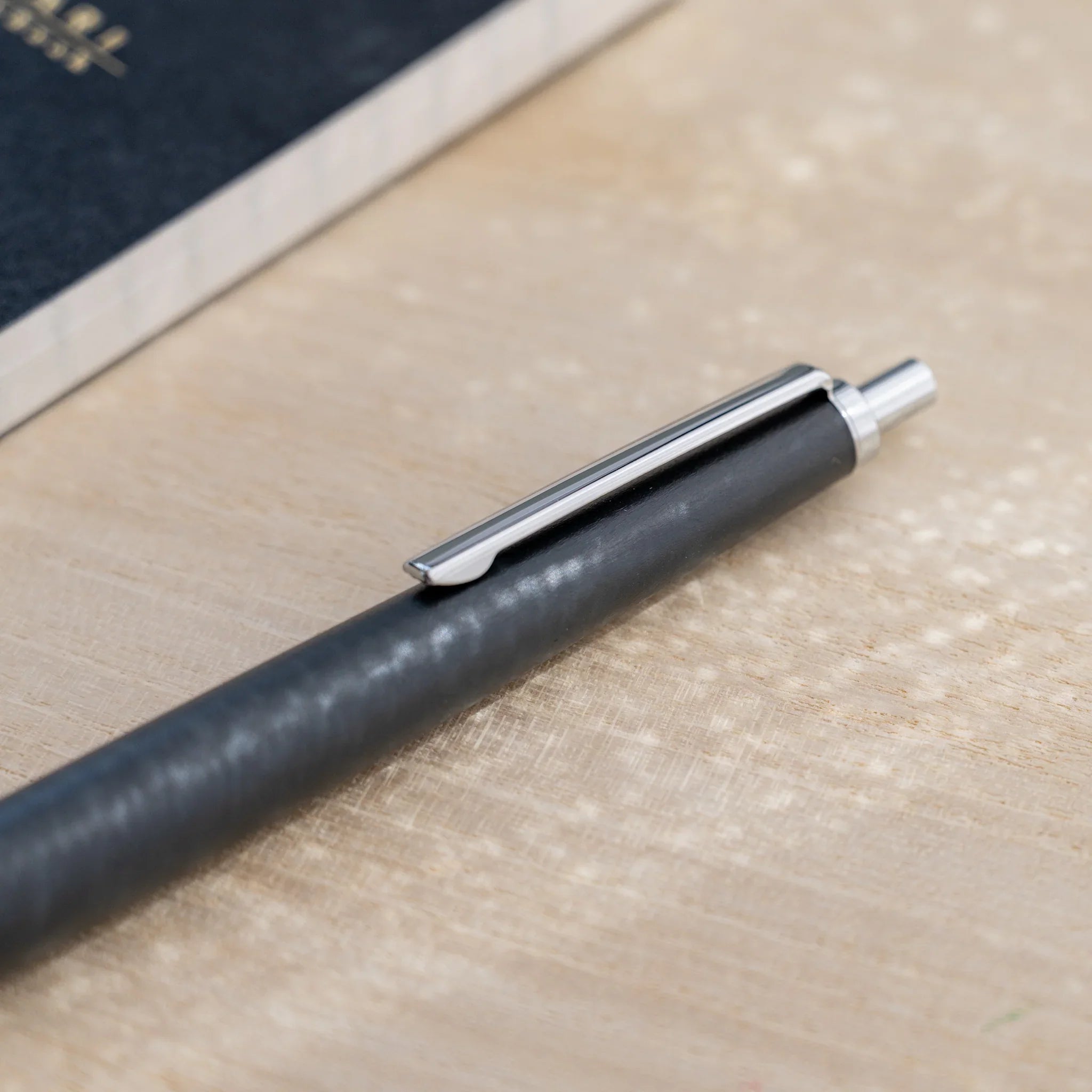 Horse chestnut wood urushi lacquered ballpoint pen in charcoal black, Japanese wood, full-body view